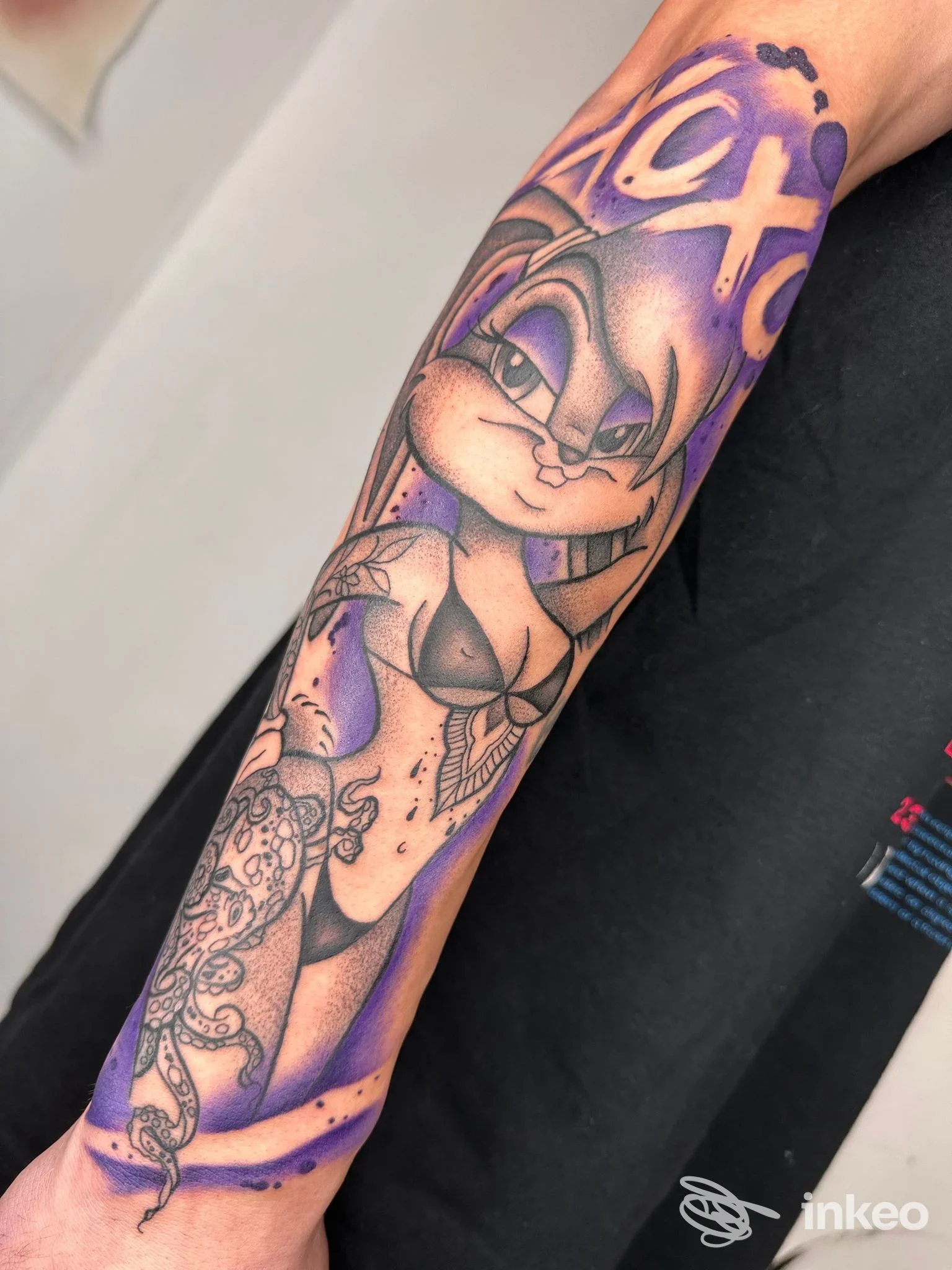 Tattoo visibile su braccio di persona, ritratto realistico di coniglio stilizzato in tonalità viola, fotografia di alta qualità.