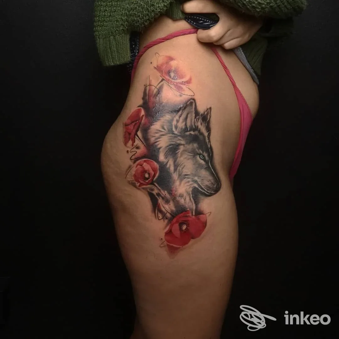 Tatuaggio realistico di un lupo con papaveri rossi sulla coscia, La Perla Nera Tattoo Ink, San Nicolò.