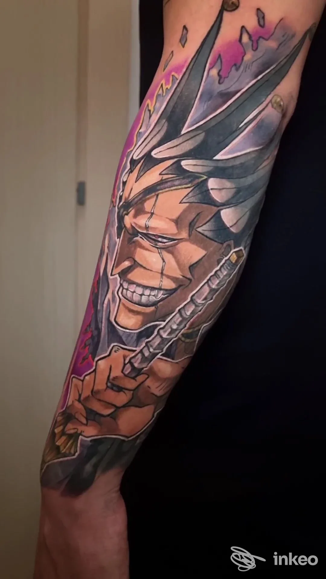 Tatuaggio a mezza manica sull'avambraccio con volto stilizzato e colori vivaci, eseguito da Lauro Tattoo a Reggio nell'Emilia.