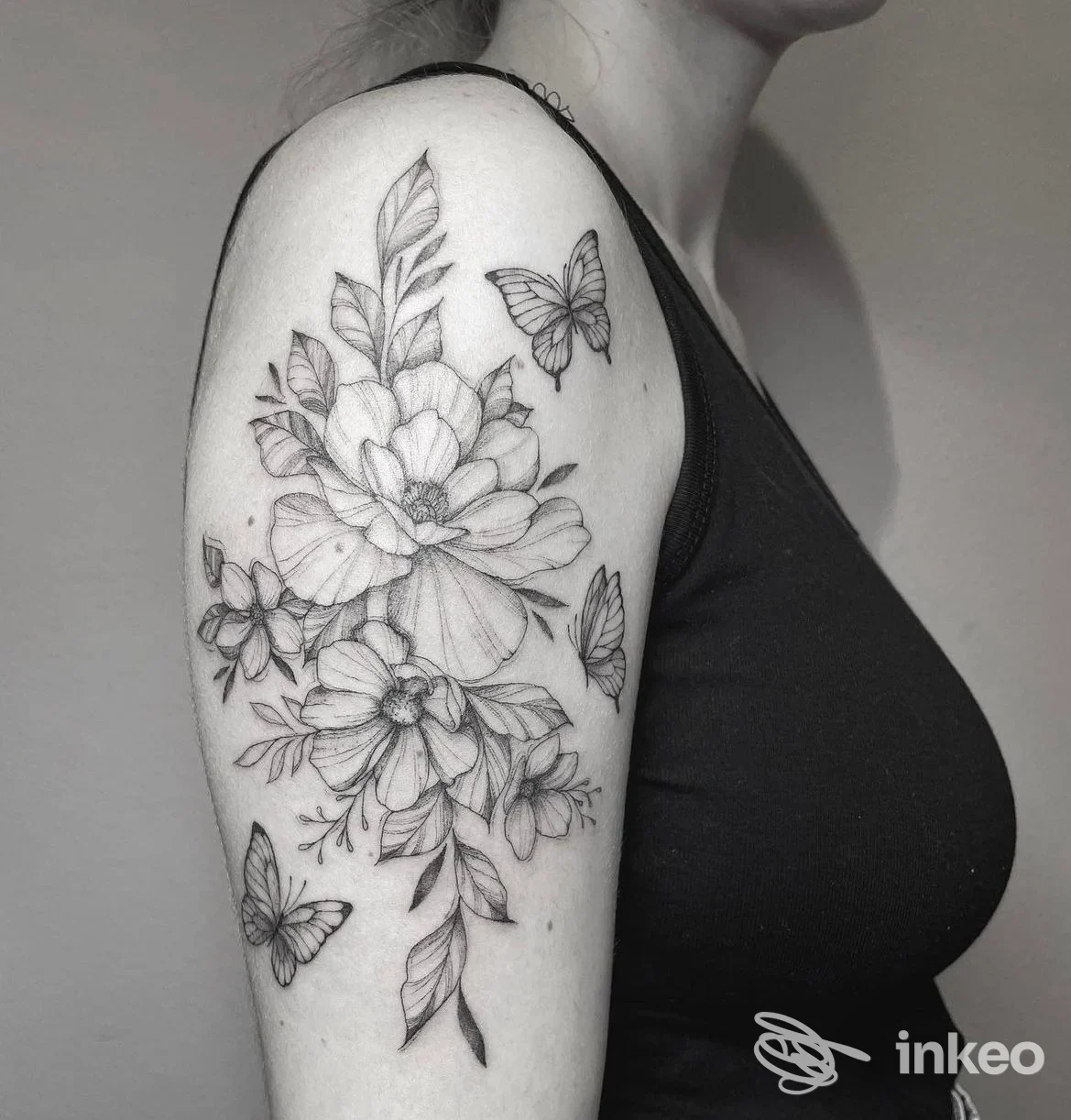 Dettaglio di tatuaggio floreale in nero e grigio sul braccio superiore, scattato presso Hills Road Tattoo Studio a Bibbiano.