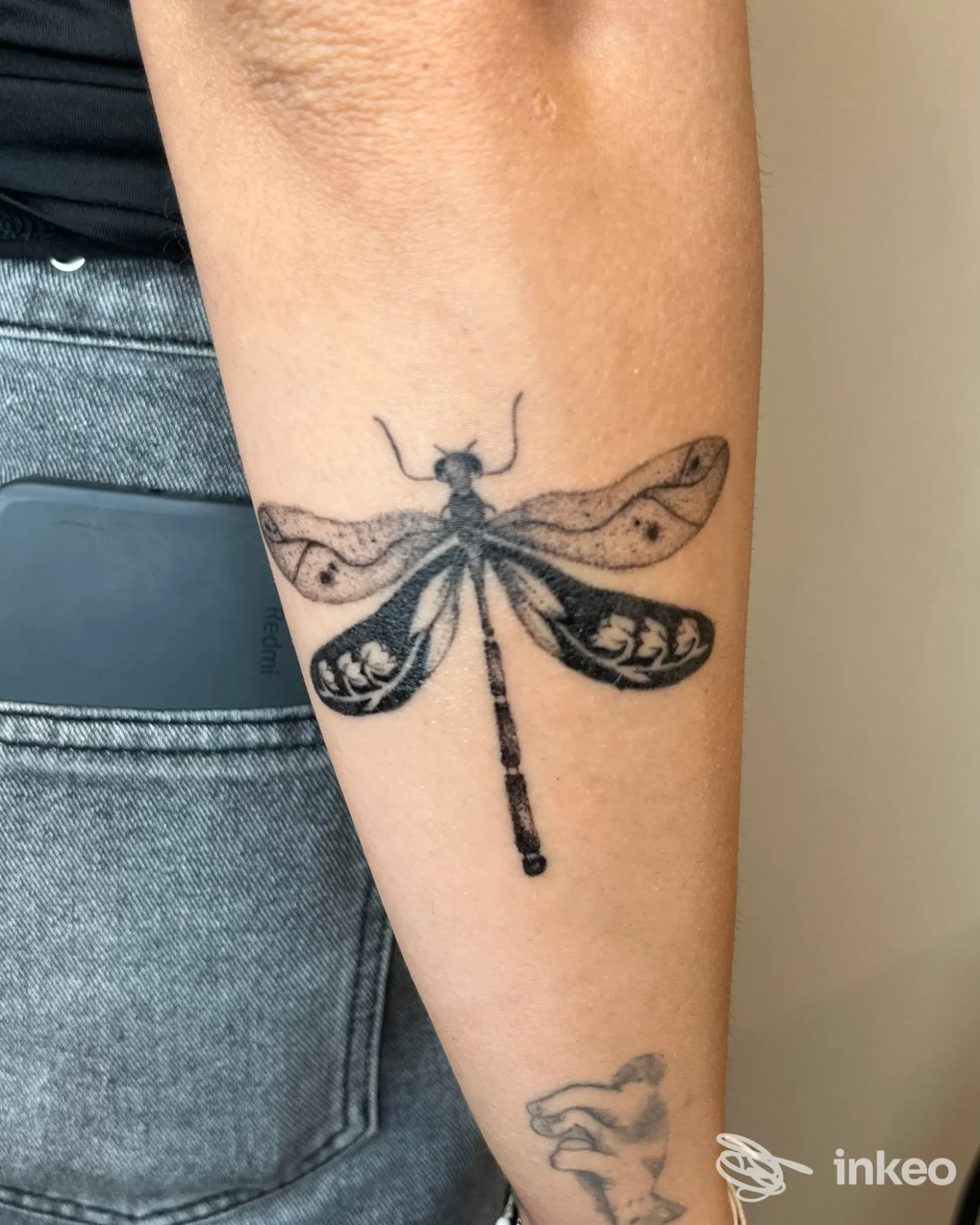 Tatuaggio a forma di libellula in nero sull'avambraccio, foto fornita da LaRossiTattoo a Bellaria-Igea Marina.
