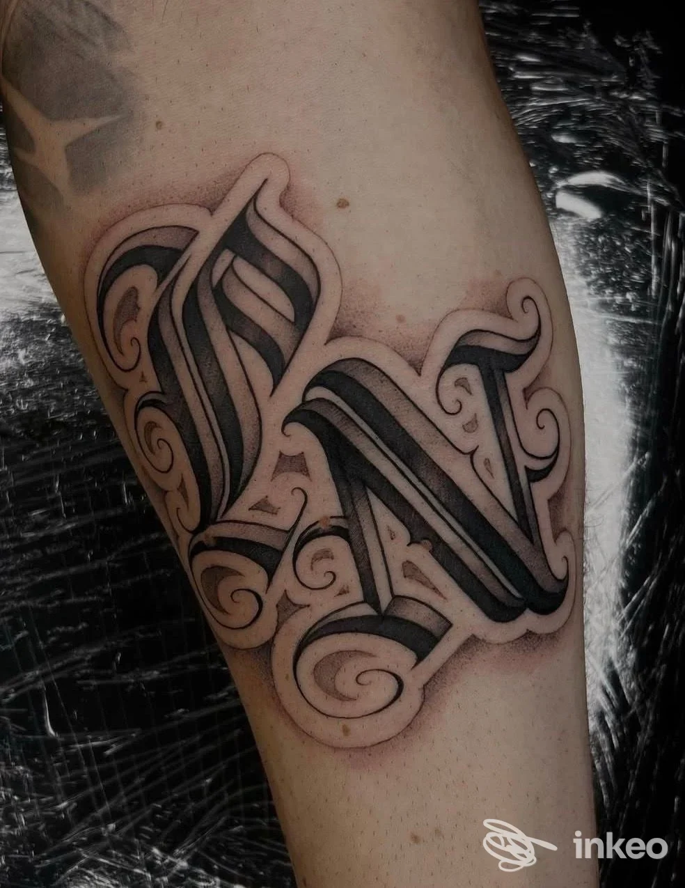 Primo piano di un tatuaggio lettering blackwork sull'avambraccio, con contorni netti e ombreggiature; foto fornita da Perseverance Tattoo Studio, Anzola dell'Emilia.