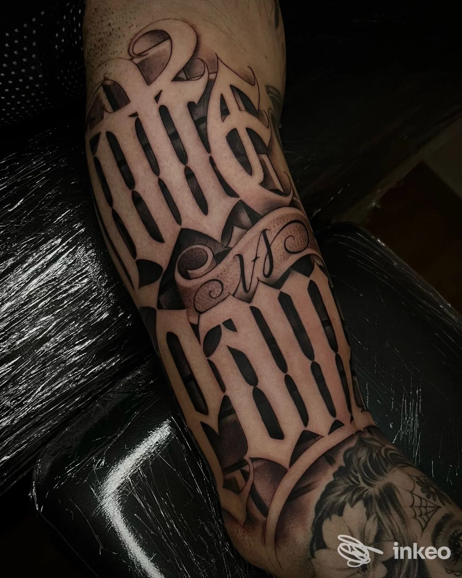 Tatuaggio lettering nero su avambraccio, con nastro calligrafico; Perseverance Tattoo Studio, Anzola dell'Emilia.