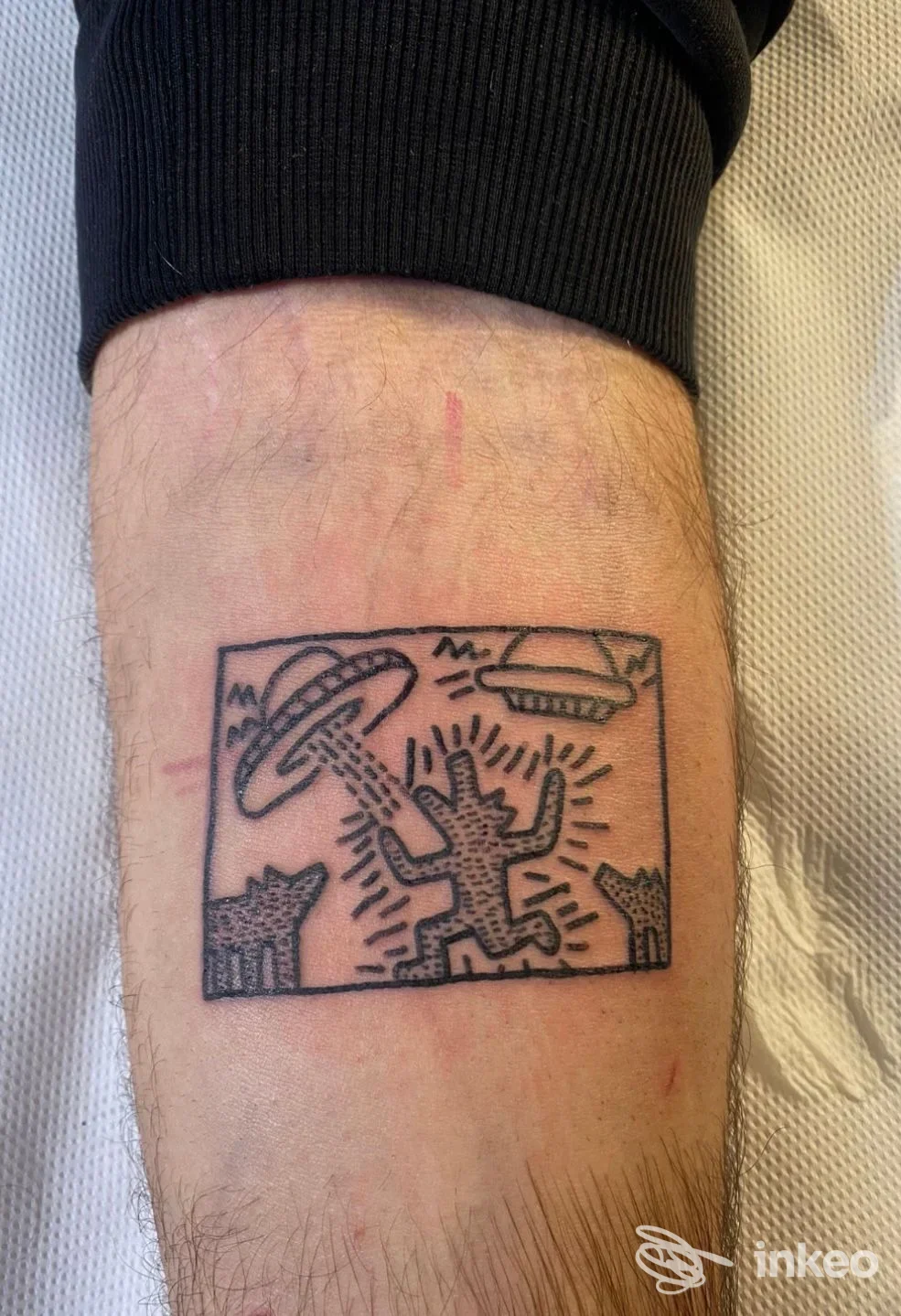 Tatuaggio a inchiostro nero con figura stilizzata in cornice rettangolare sull'avambraccio. NeroForte Tattoo&Piercing, Vignola.