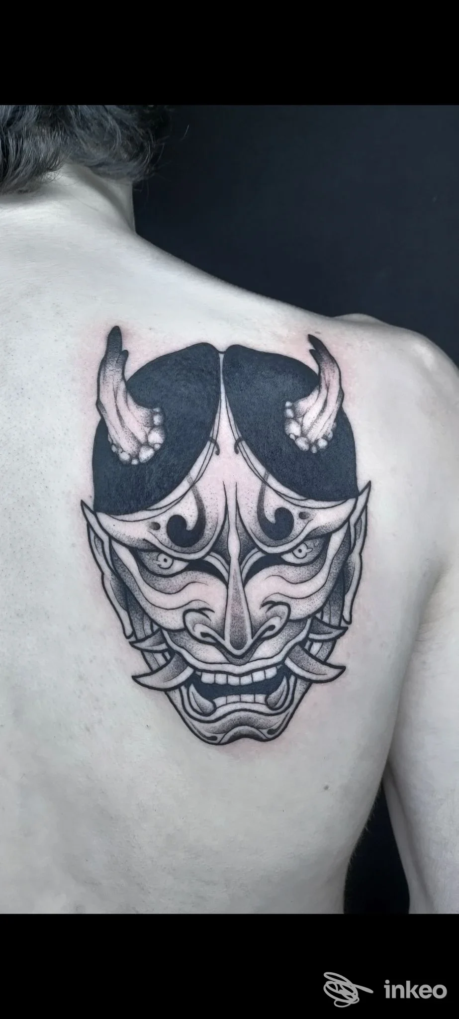 Grande tatuaggio di maschera oni in nero e grigio sulla parte superiore della schiena, fotografato per Owlink Tattoo a Vezzano sul Crostolo.