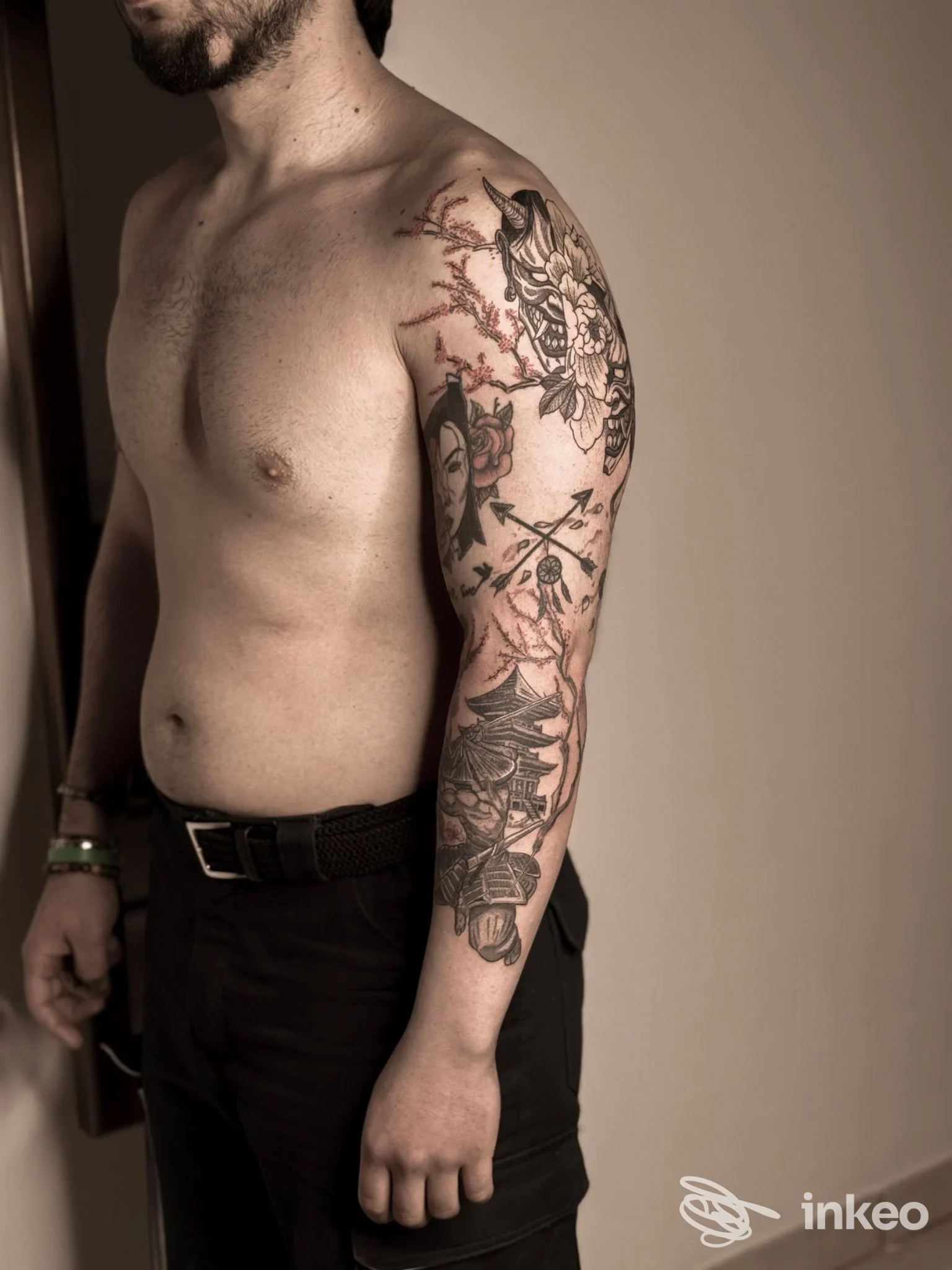 Braccio destro e spalla con manica di tatuaggi su pelle reale, ritratto parziale di un cliente nello studio Secret Ink Tattoo a Longiano.