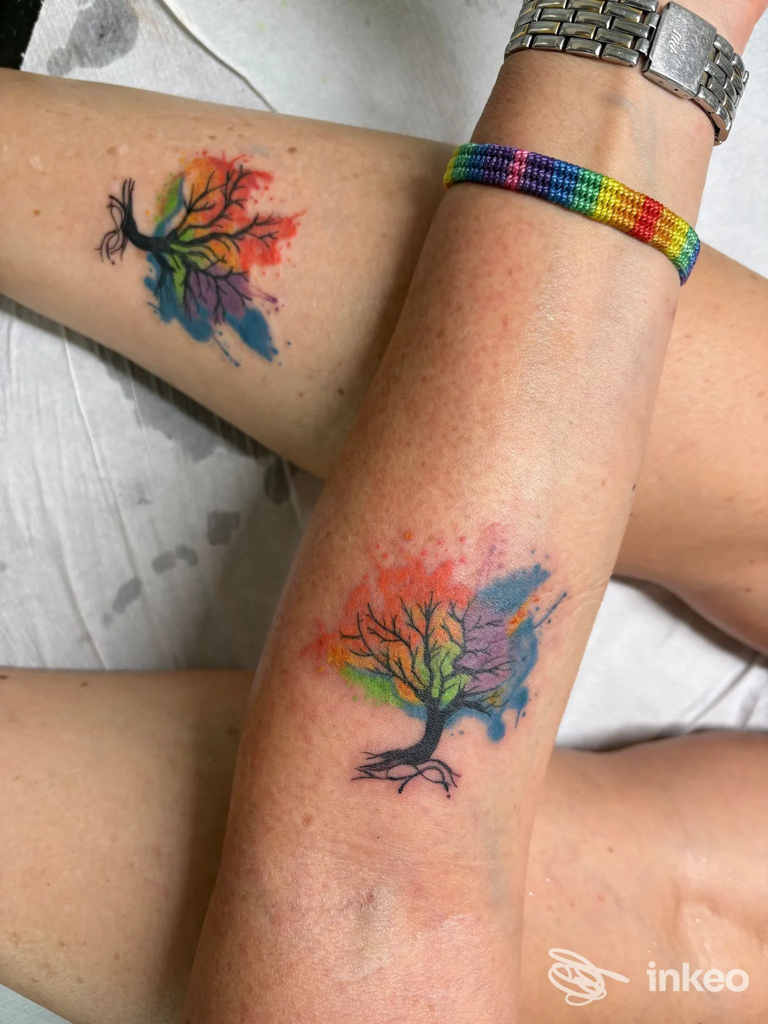 Due avambracci con tatuaggi a forma di albero in stile acquerello; lavoro eseguito da Oceania Tattoo, San Cesario sul Panaro.