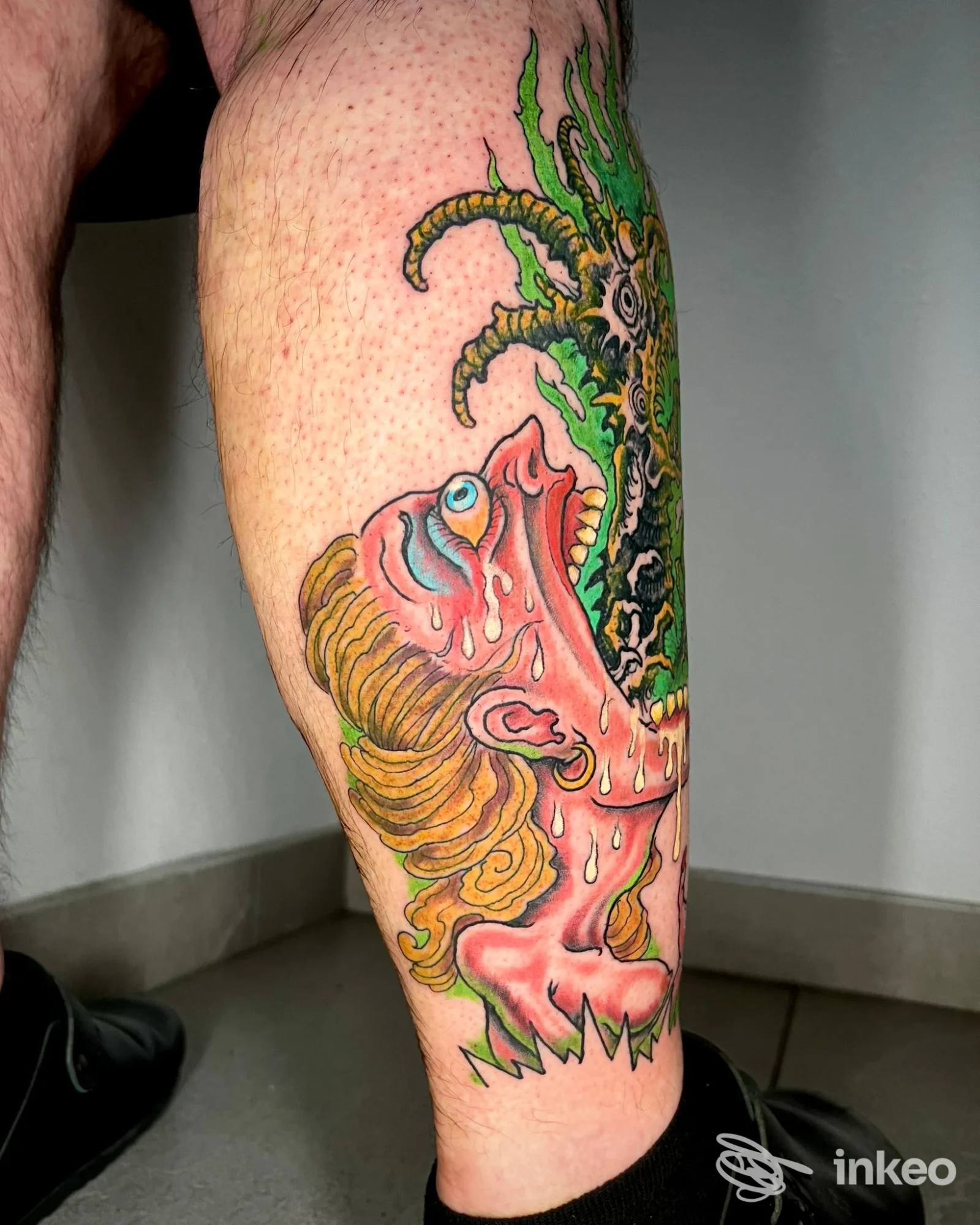 Tatuaggio colorato su polpaccio fotografato in interno, opera mostrata da Homeless Tattoo Piercing & Streetwear a Piacenza.