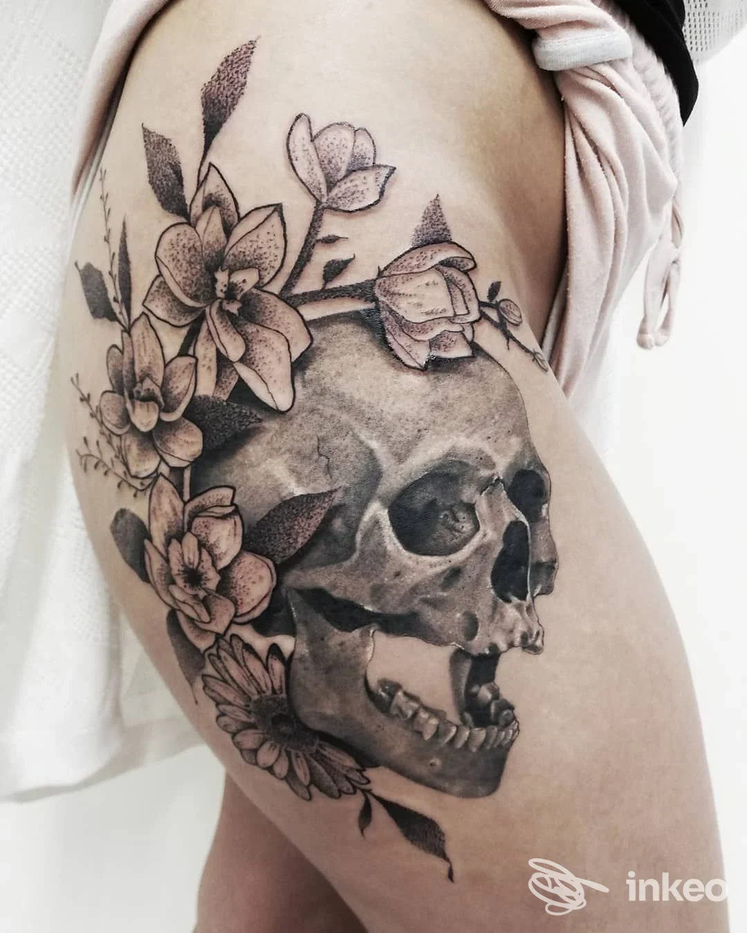 Grande tatuaggio black-and-grey di teschio e fiori sulla coscia, Sole nero tattoostudio, San Mauro Pascoli.