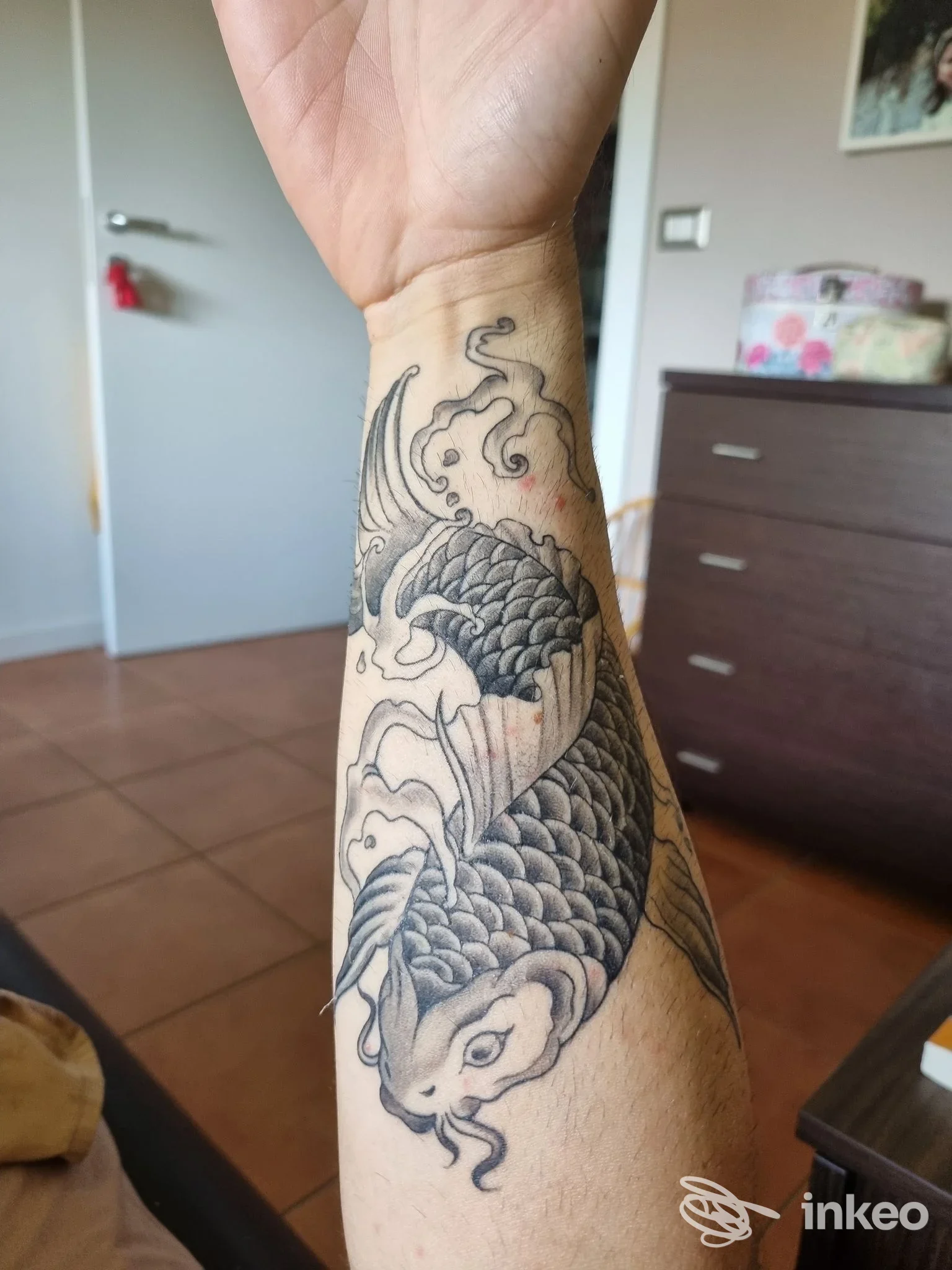 Tatuaggio di una carpa koi in bianco e nero sull'avambraccio, foto fornita dallo studio Carlo Monari a Sasso Marconi.