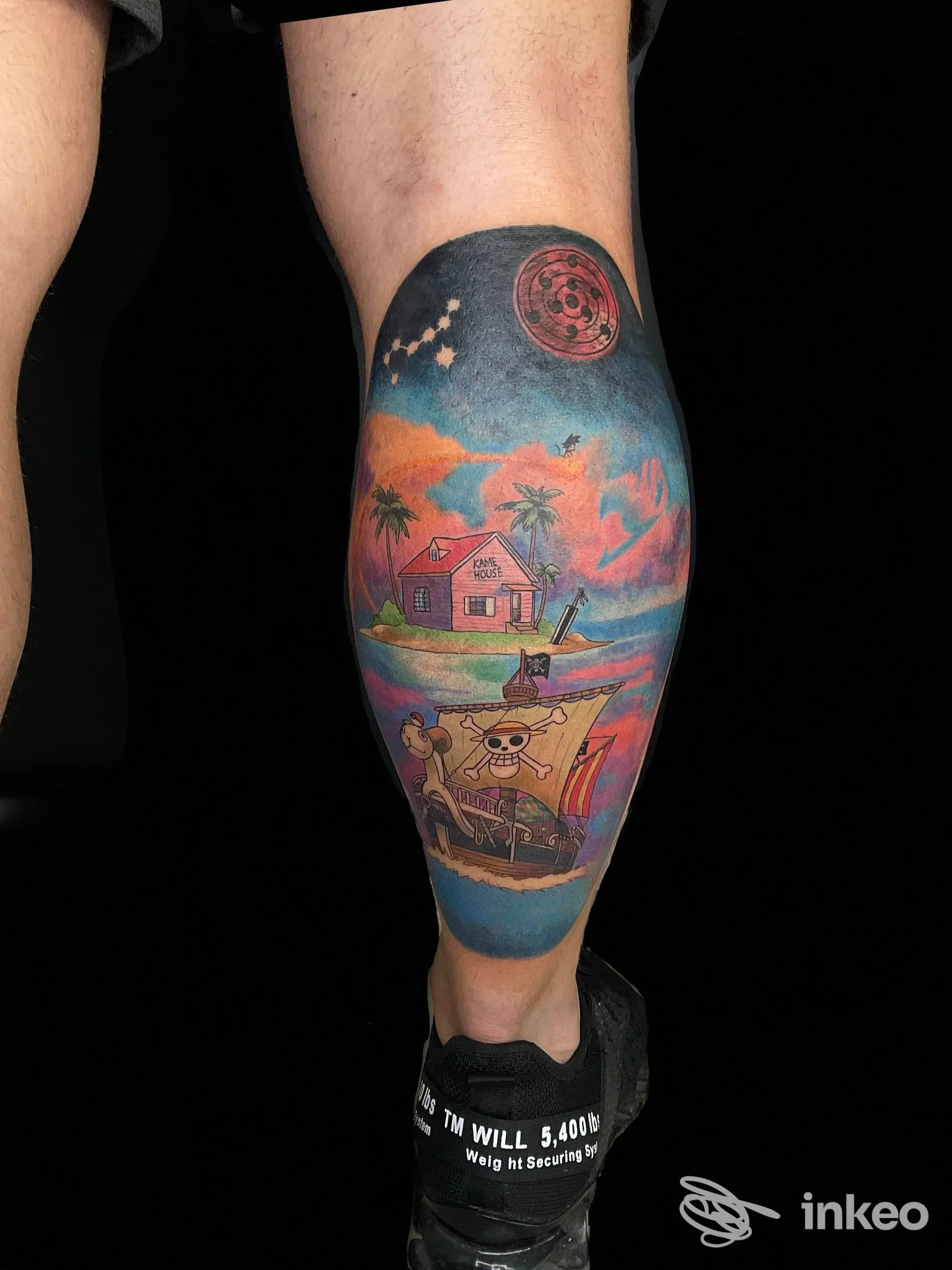 Tatuaggio colorato su polpaccio raffigurante scena tropicale e personaggi fumettosi, realizzato da InkWish a Cattolica.