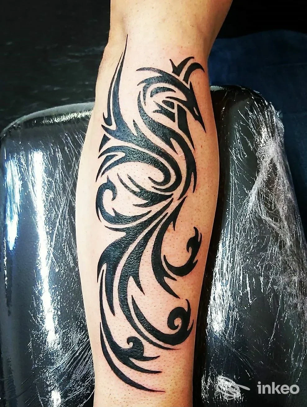 Tatuaggio tribale nero su avambraccio, foto scattata su lettino con pellicola protettiva; La Tatueria della Sha, Villa Minozzo.