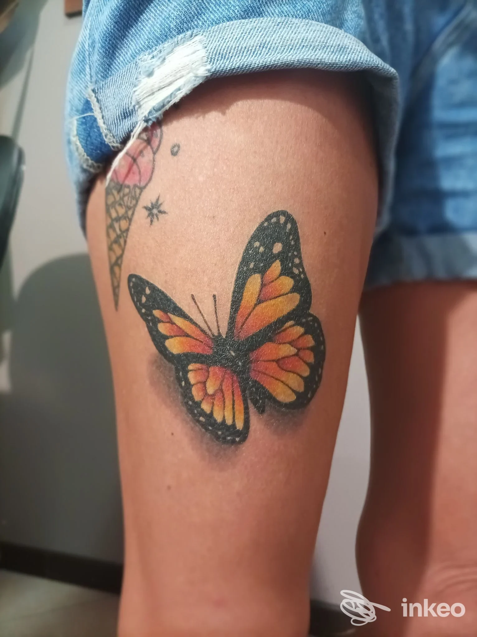 Tatuaggio farfalla colorata sulla coscia, foto inviata dallo studio Vintage Tattoo Shop a Ferrara.