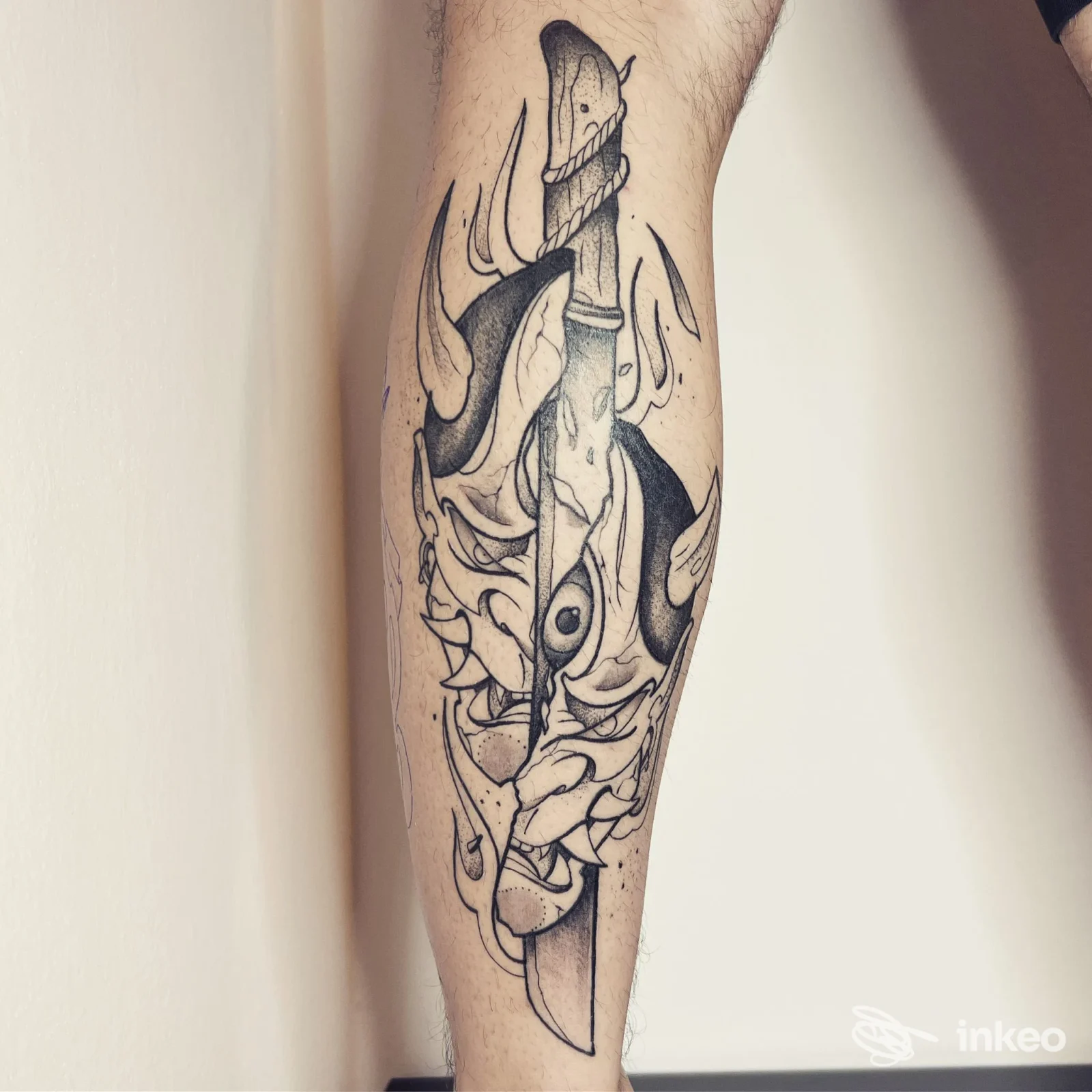 Tatuaggio in bianco e nero a forma di lama stilizzata sul polpaccio, foto fornita da Bear tattoo studio a Reggio nell'Emilia.