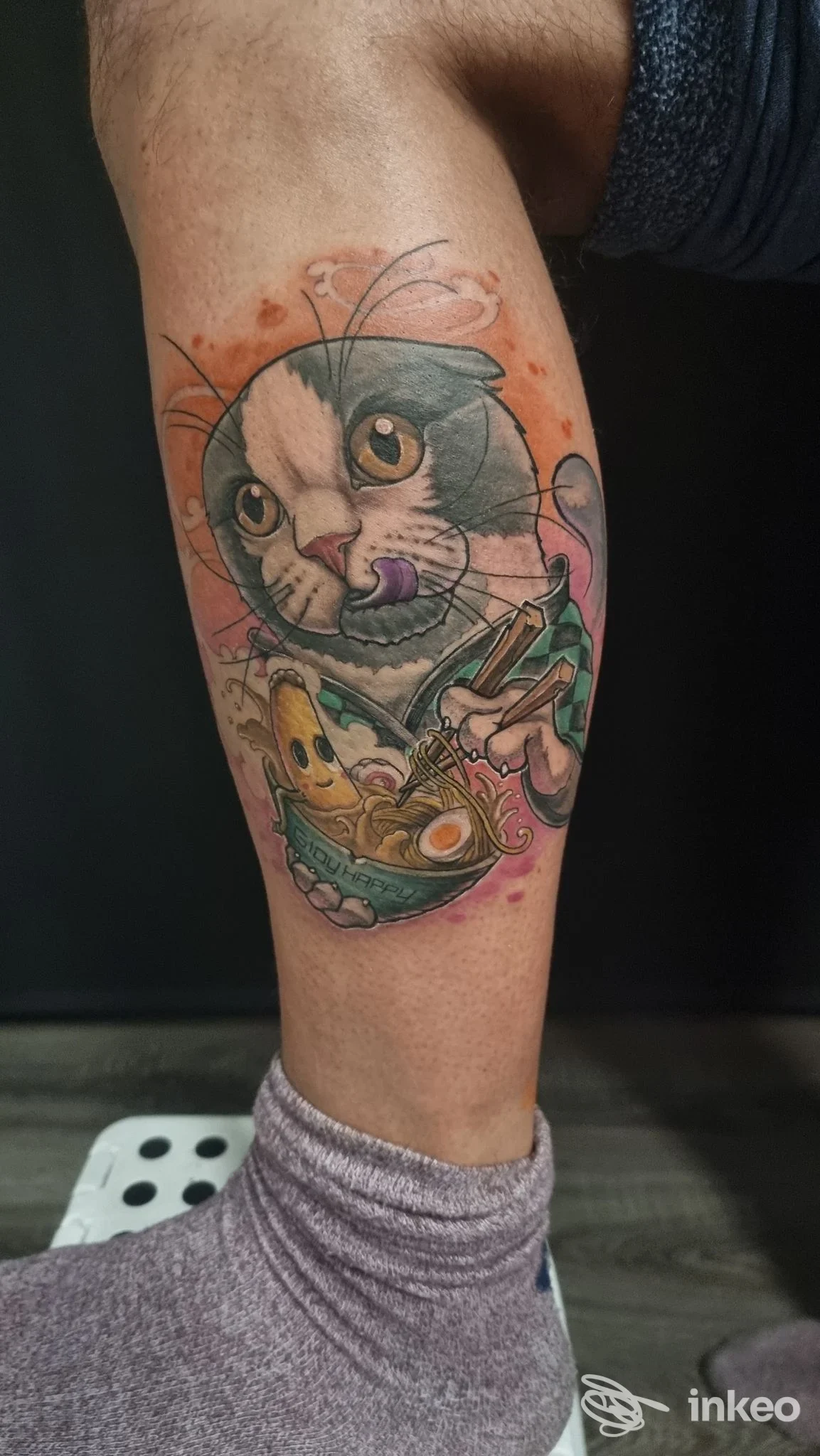 Tatuaggio colorato su polpaccio raffigurante un gatto che mangia ramen — Trip Art Tattoo & Piercing 2.0, Cerasolo.