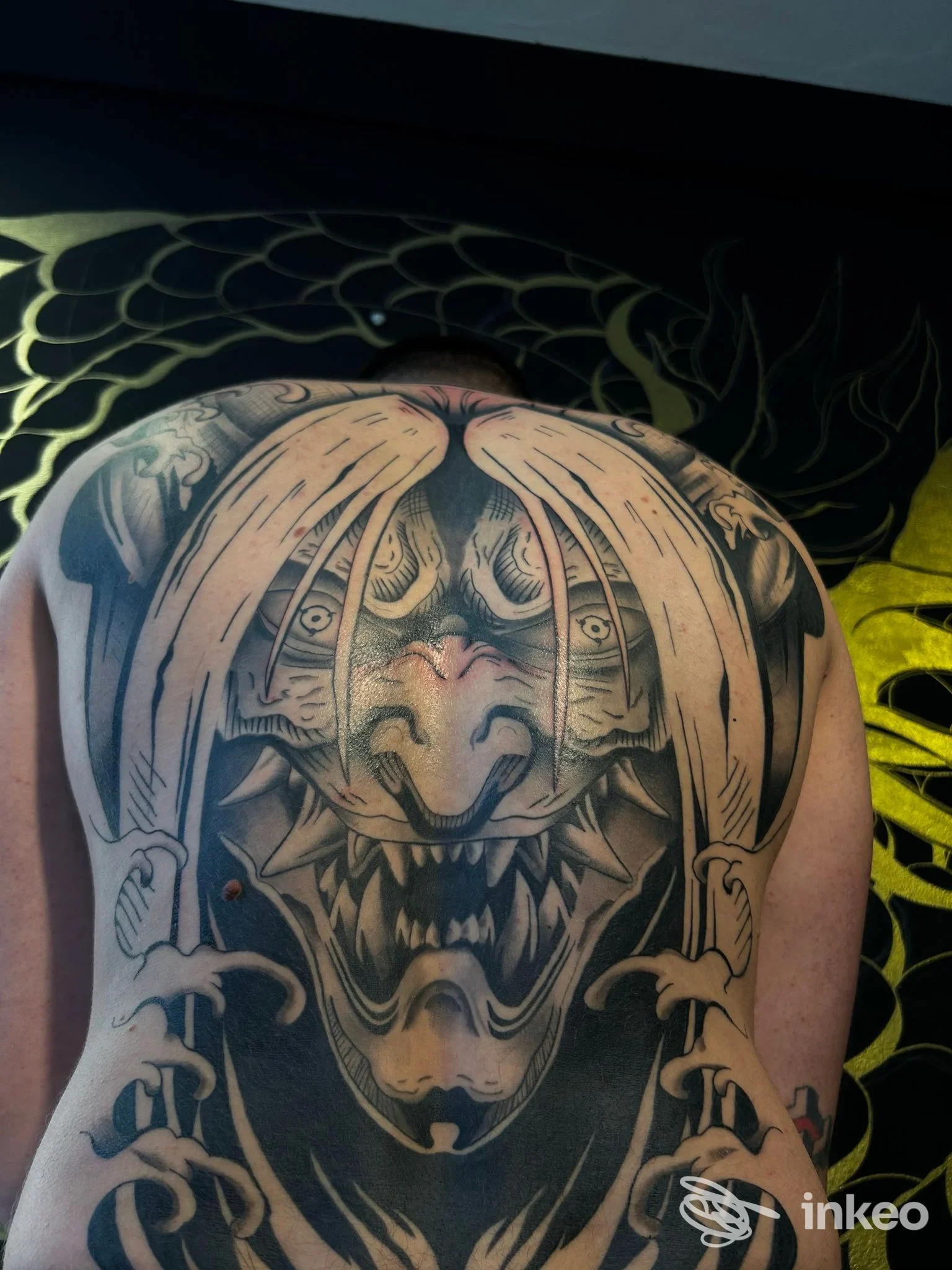 Tatuaggio a tutta schiena con maschera demoniaca in bianco e nero, foto fornita da Sviringi Tattoo&Piercing, Reggio nell'Emilia.