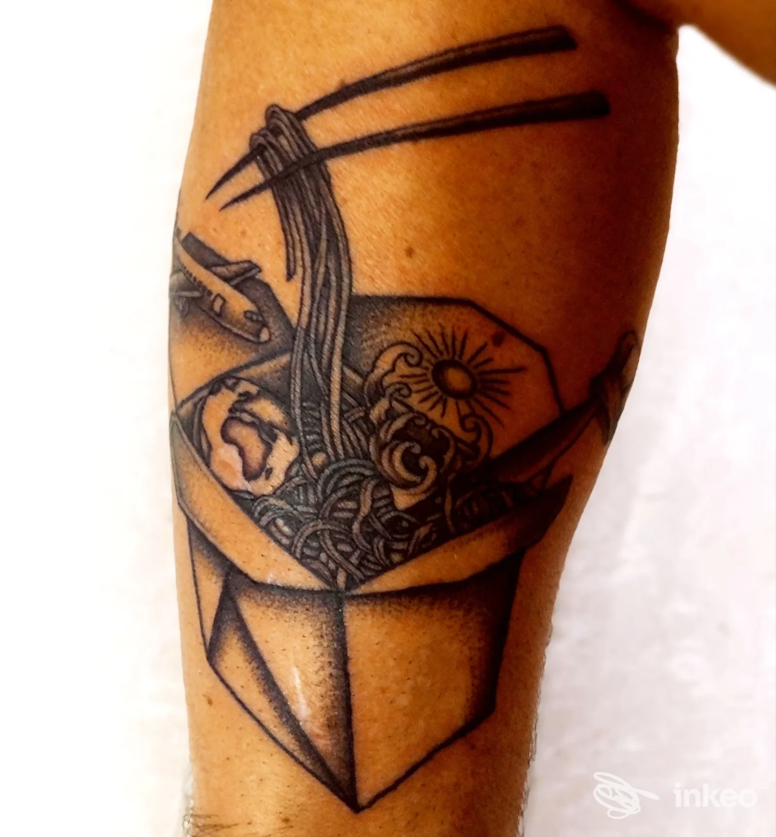 Tatuaggio su avambraccio raffigurante una scatola di noodles con bacchette — All Ink Tattoo, Forlì.