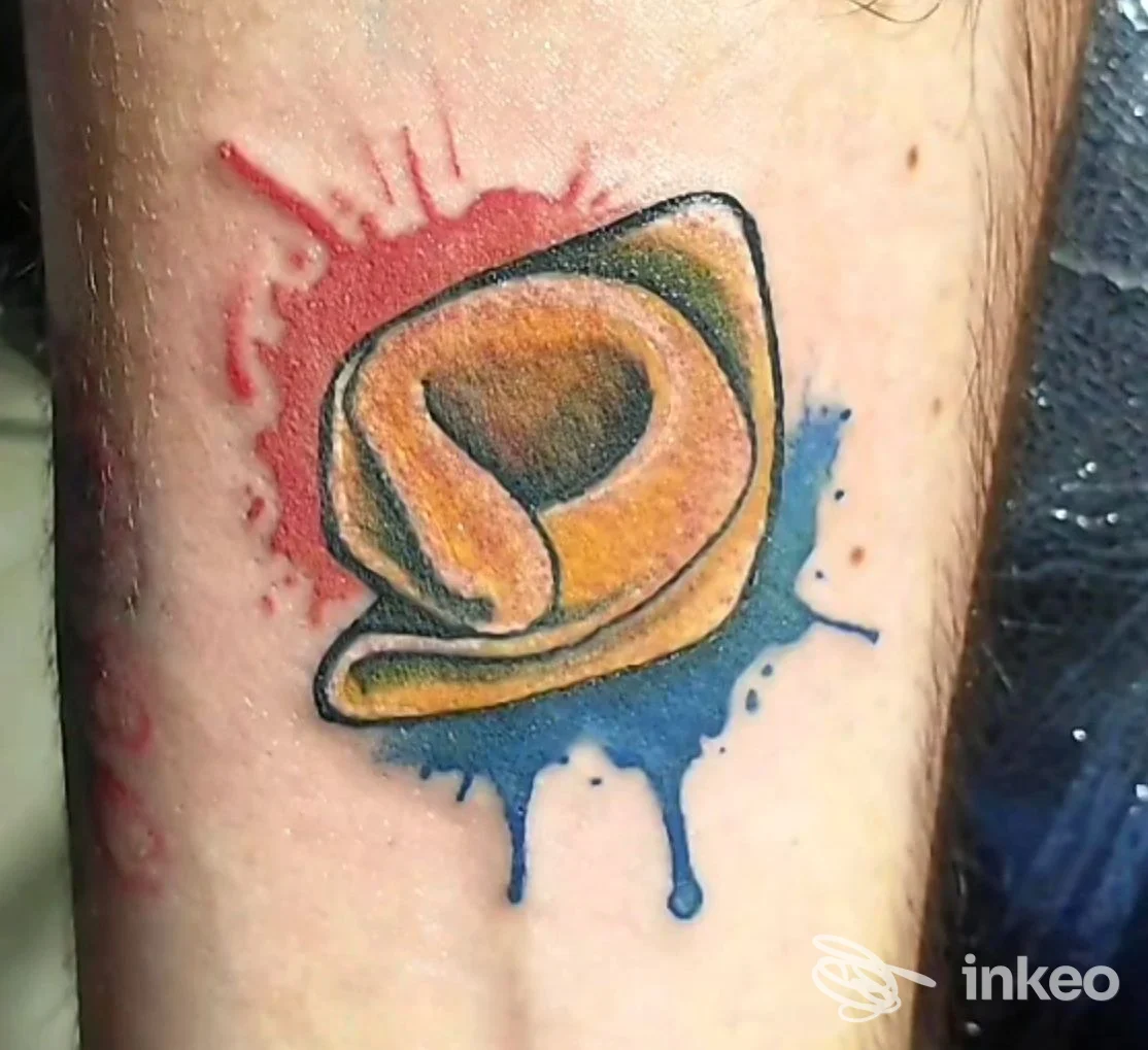 Tatuaggio colorato su avambraccio con macchie rosse e blu, Ludipea Tattoo, San Pietro in Casale.