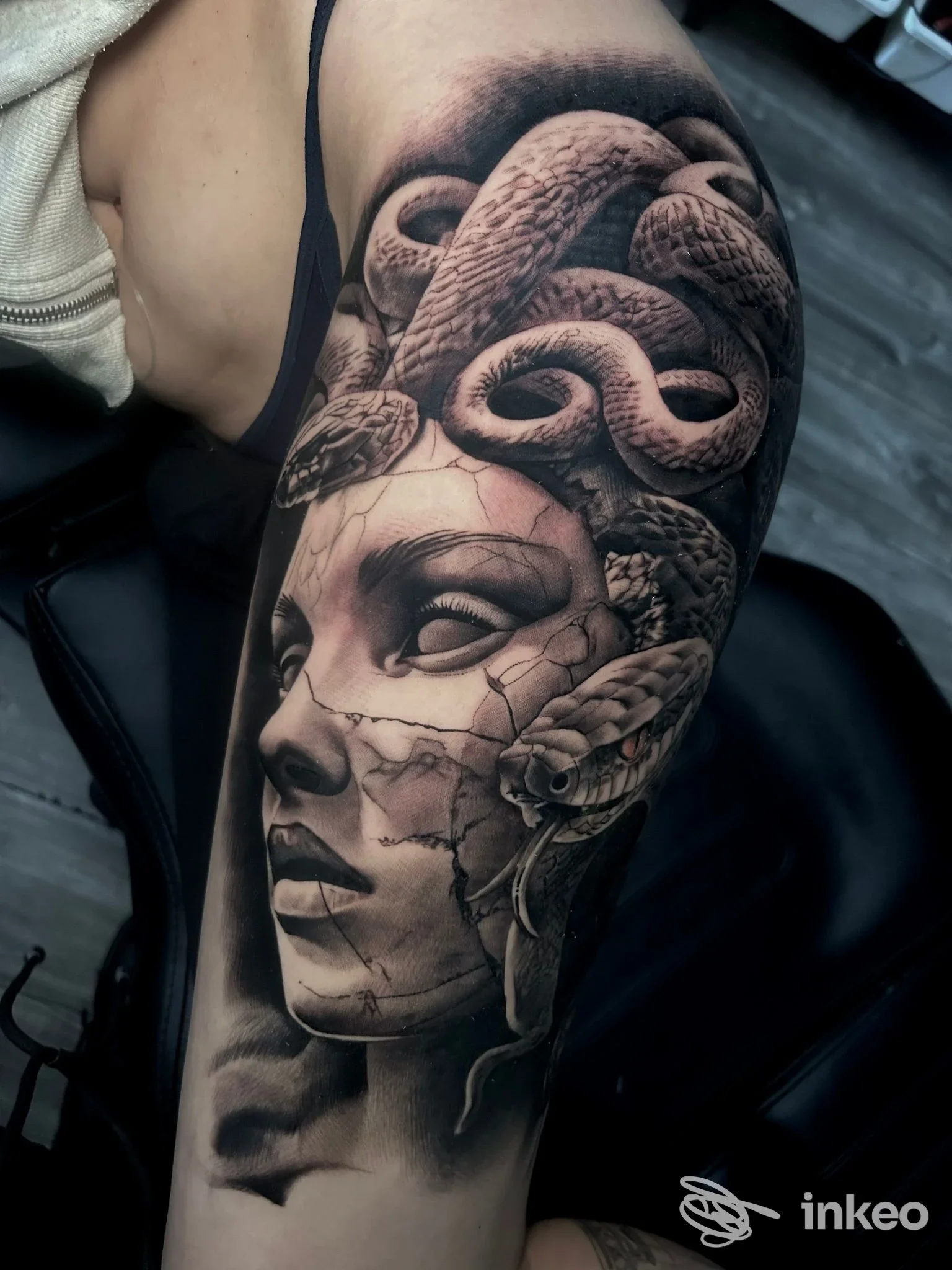 Tatuaggio realistico a braccio con volto scolpito e serpenti, Happy Days Tattoo Studio, Reggio nell'Emilia.