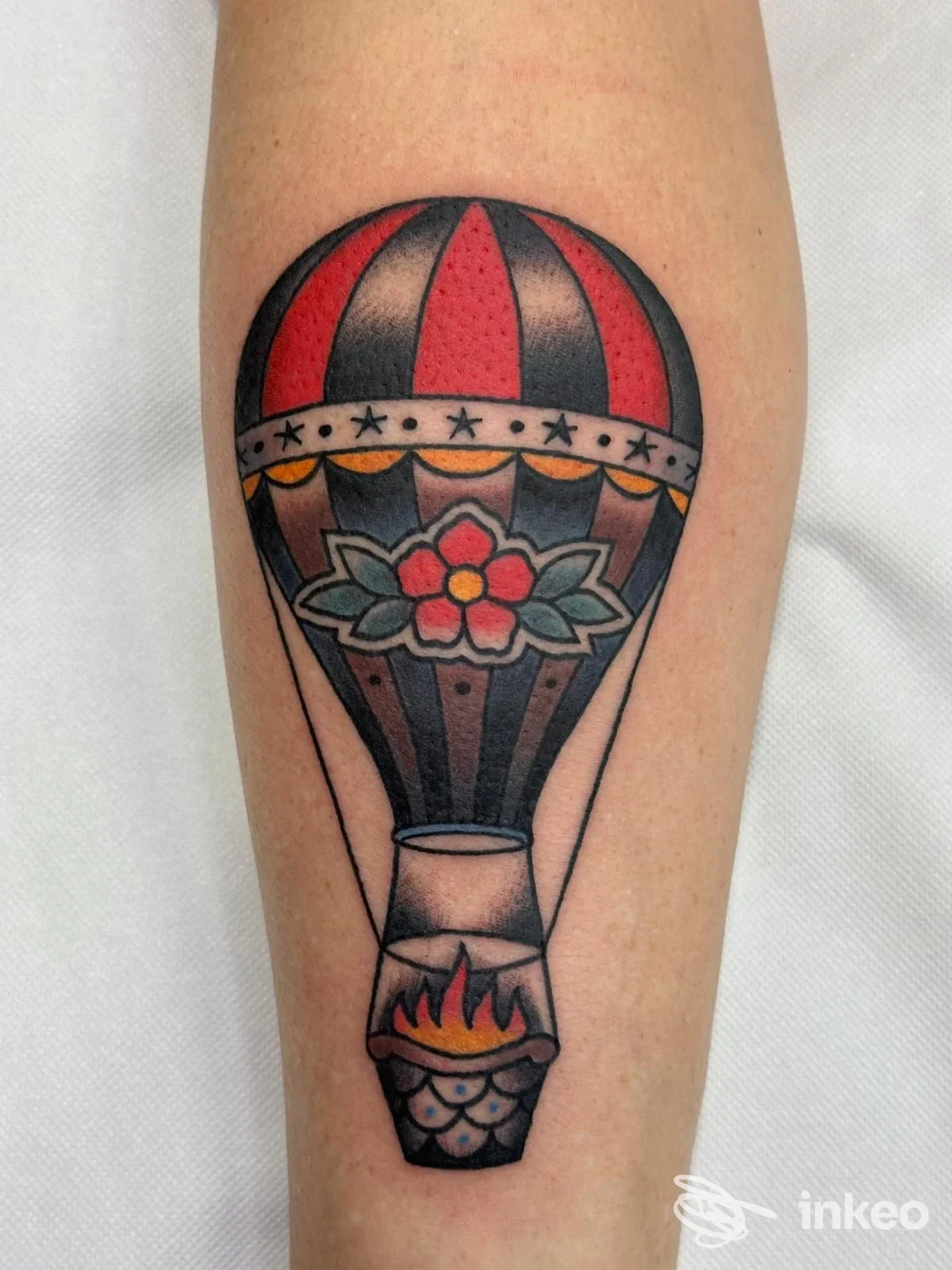 Tatuaggio stile tradizionale di una mongolfiera colorata sull'avambraccio, realizzato da Skinwear Tattoo Shop a Rimini.
