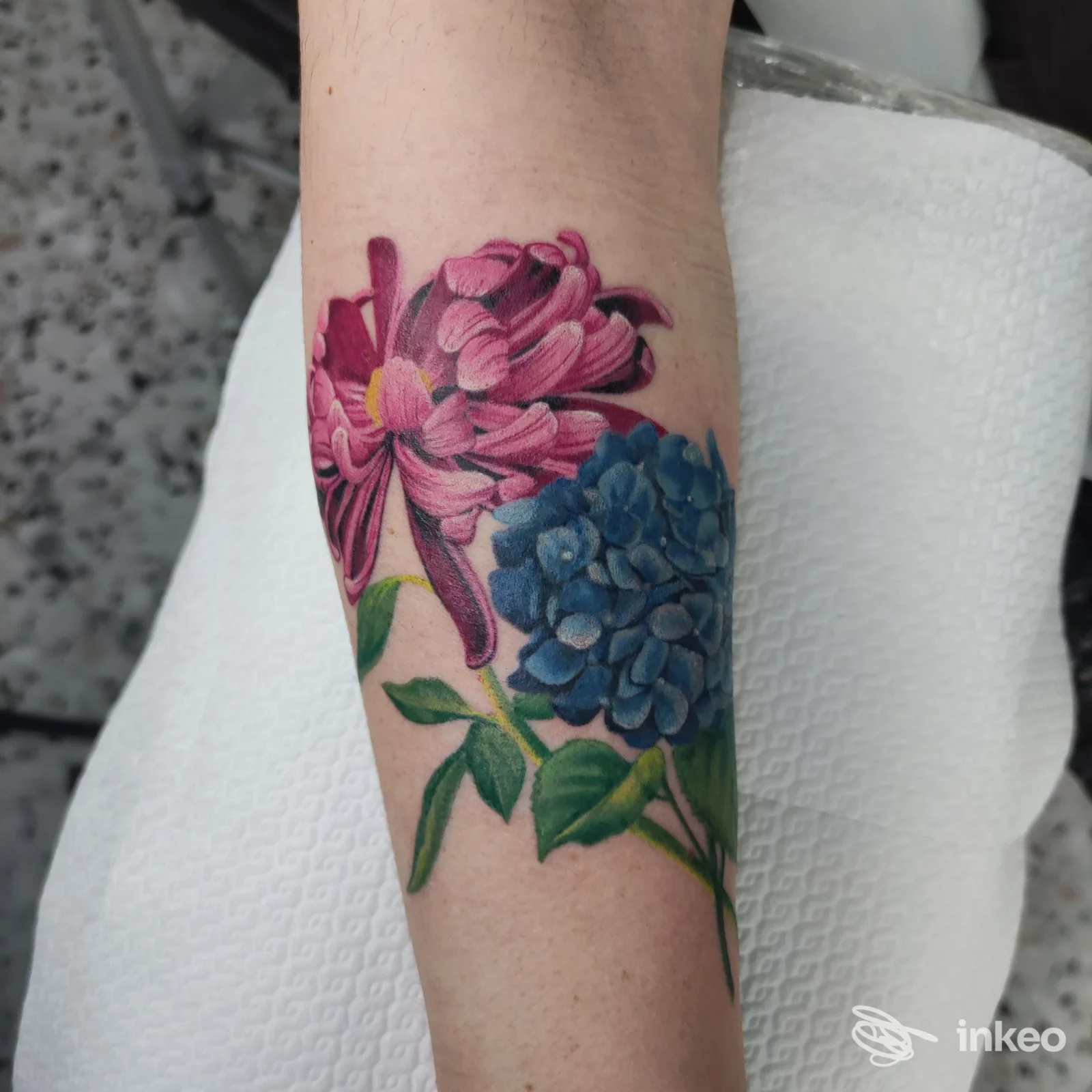 Tatuaggio floreale realistico sul lato interno dell'avambraccio con crisantemo rosa e ortensia blu, Tattoo Atelier Sonia Savi, Sala Baganza.