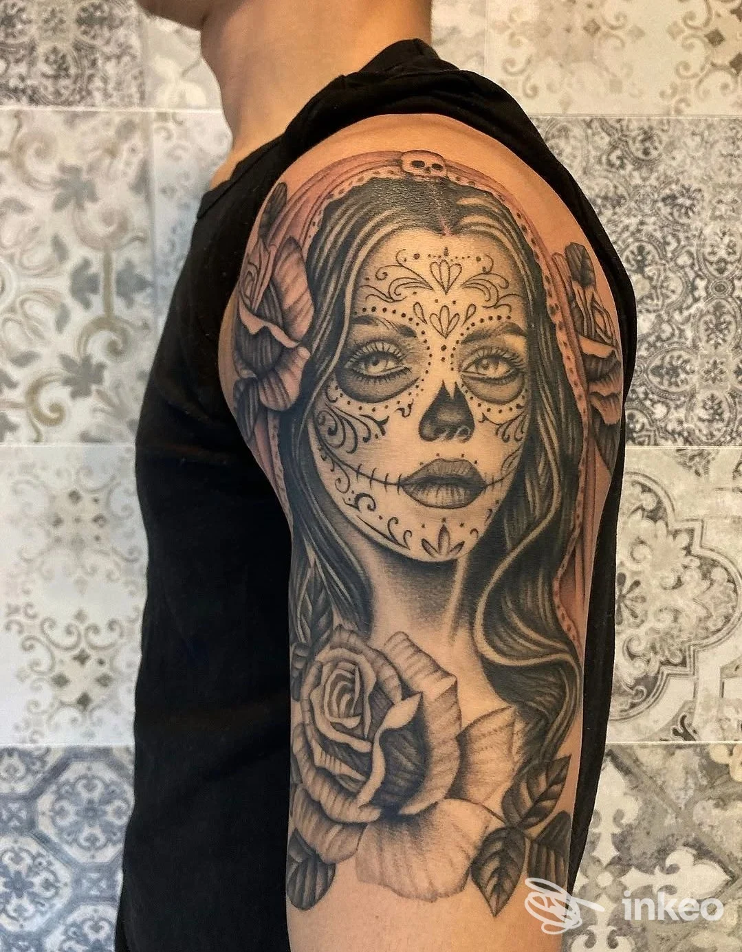 Tatuaggio a manica sulla spalla con volto in stile calavera e rose, Pazienza Tattoo Studio, Reggio Emilia.