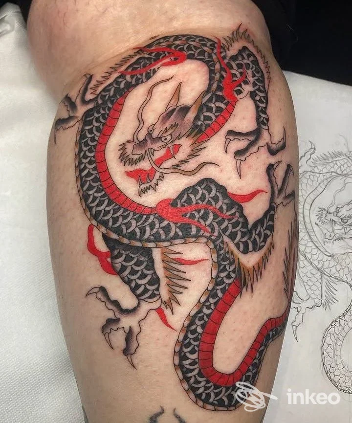 Tatuaggio a drago in nero e rosso sulla coscia, Pazienza Tattoo Studio, Reggio Emilia.