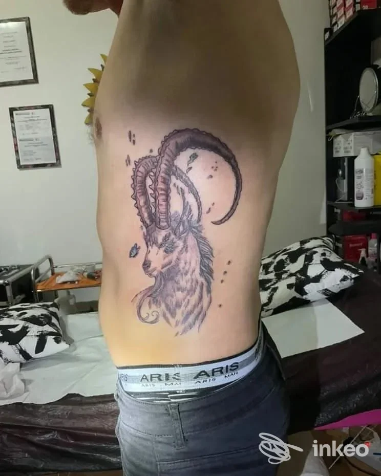 Grande tatuaggio laterale raffigurante una capra cornuta sul fianco di un uomo, fotografato presso Mary88Ink Tattoo and Piercing a Castelvetro di Modena.