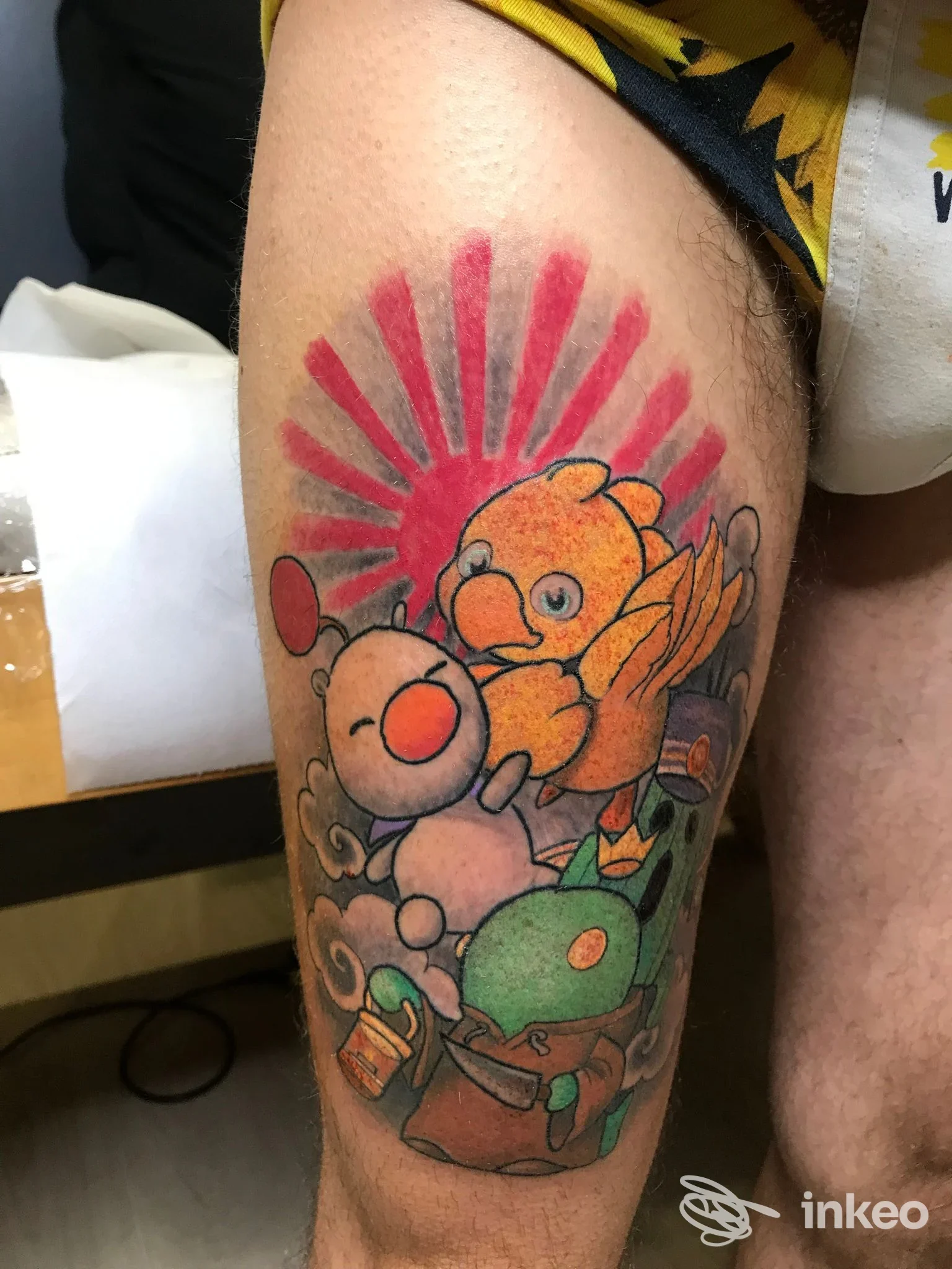 Tatuaggio colorato sulla coscia con personaggi fumettistici e raggiera rossa, foto fornita da The Black Hobo Society Tattoo & Piercing, Bologna.