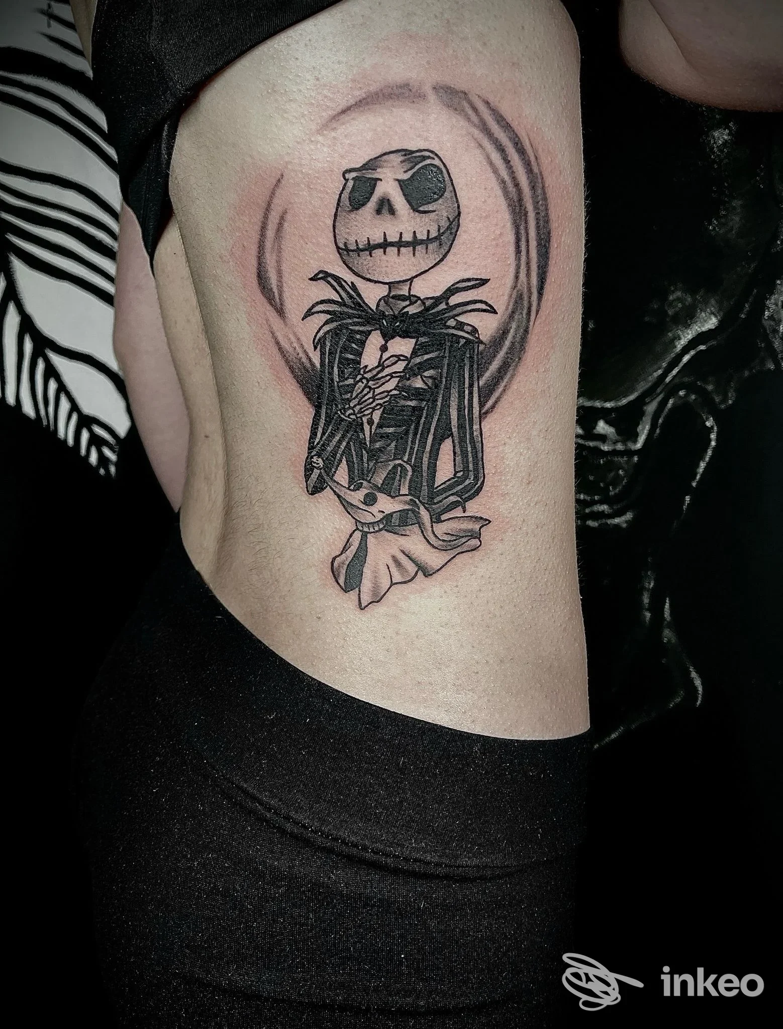 Tatuaggio in bianco e nero sul fianco con personaggio scheletrico, foto fornita da Trust The Line - Tattoo Studio, Codroipo.