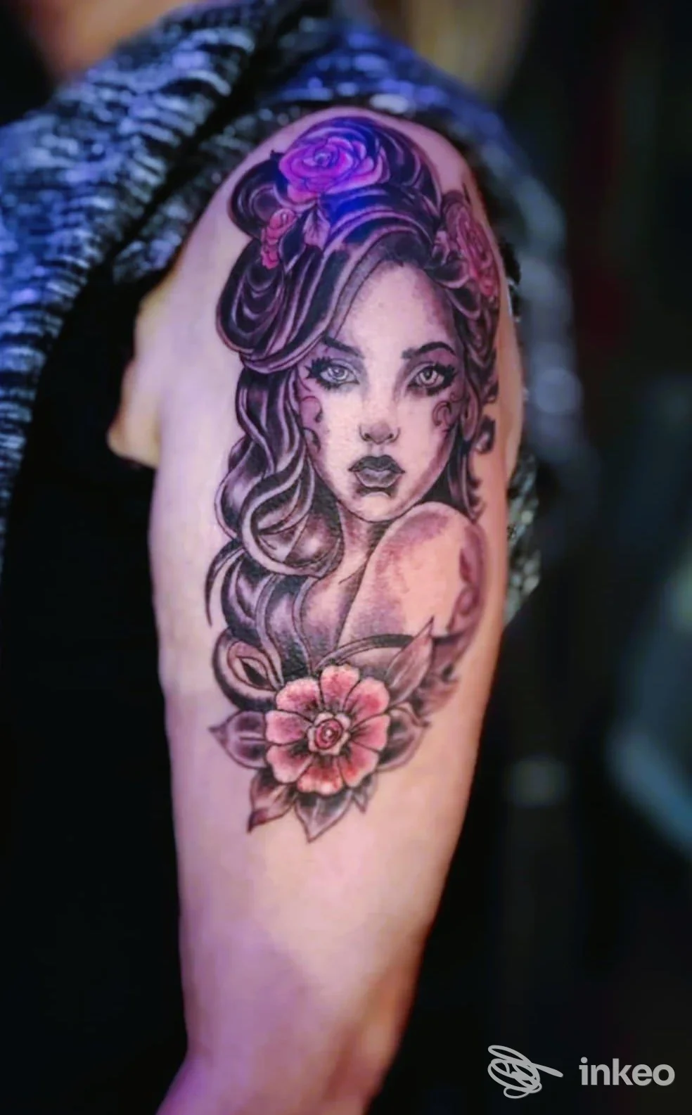 Tatuaggio su braccio con volto femminile stilizzato e fiori, realizzato da Tattoo World a Trieste.