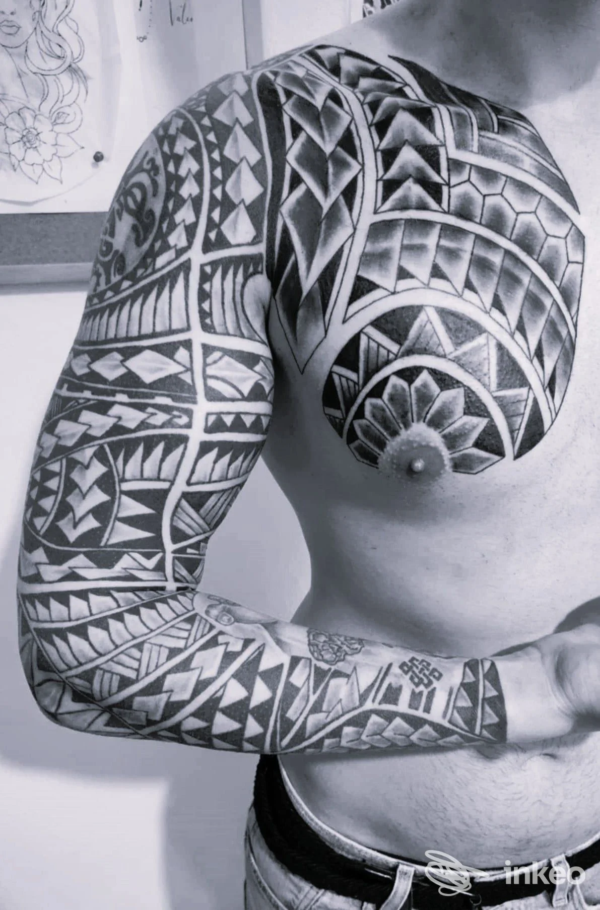 Ampio tatuaggio tribale su petto e braccio sinistro, fotografia in studio. Tattoo World, Trieste.