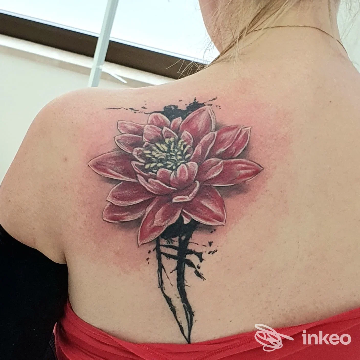 Grande tatuaggio floreale rosa con effetto splash sulla scapola destra, realizzato da WANDERLUSTATTOO a Buia.