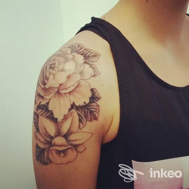 Foto di un tatuaggio floreale in bianco e nero sulla spalla di una persona, realizzato da Alterink Tattooz a Codroipo.