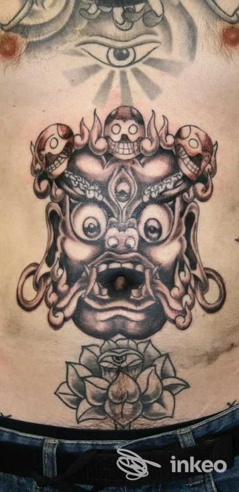 Ampio tatuaggio sull'addome raffigurante una maschera demoniaca con un fiore sotto, foto fornita da Alterink Tattooz, Codroipo.