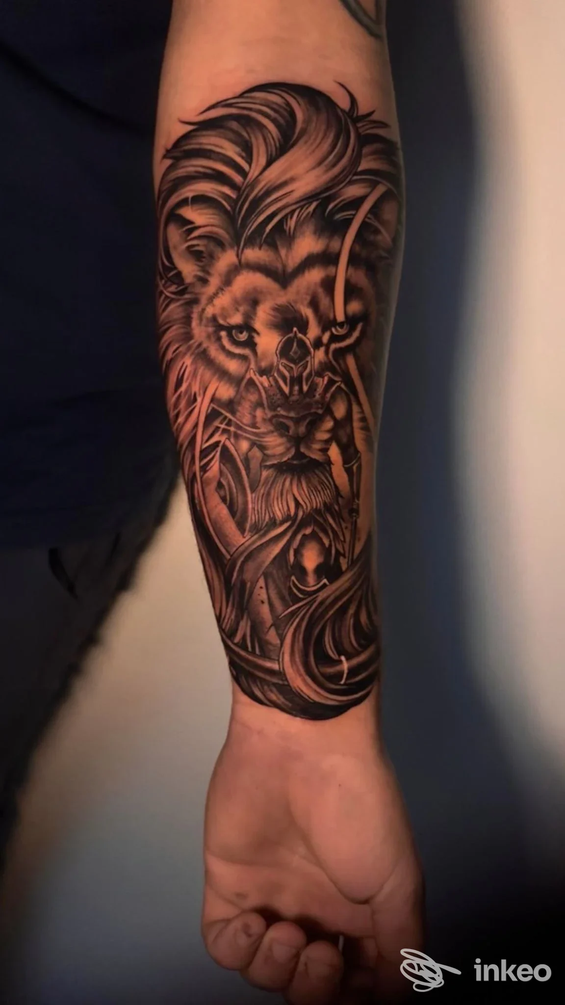 Tatuaggio realistico in nero e grigio di un leone sull'avambraccio, foto inviata da Custom Way Tattoo a Gorizia.