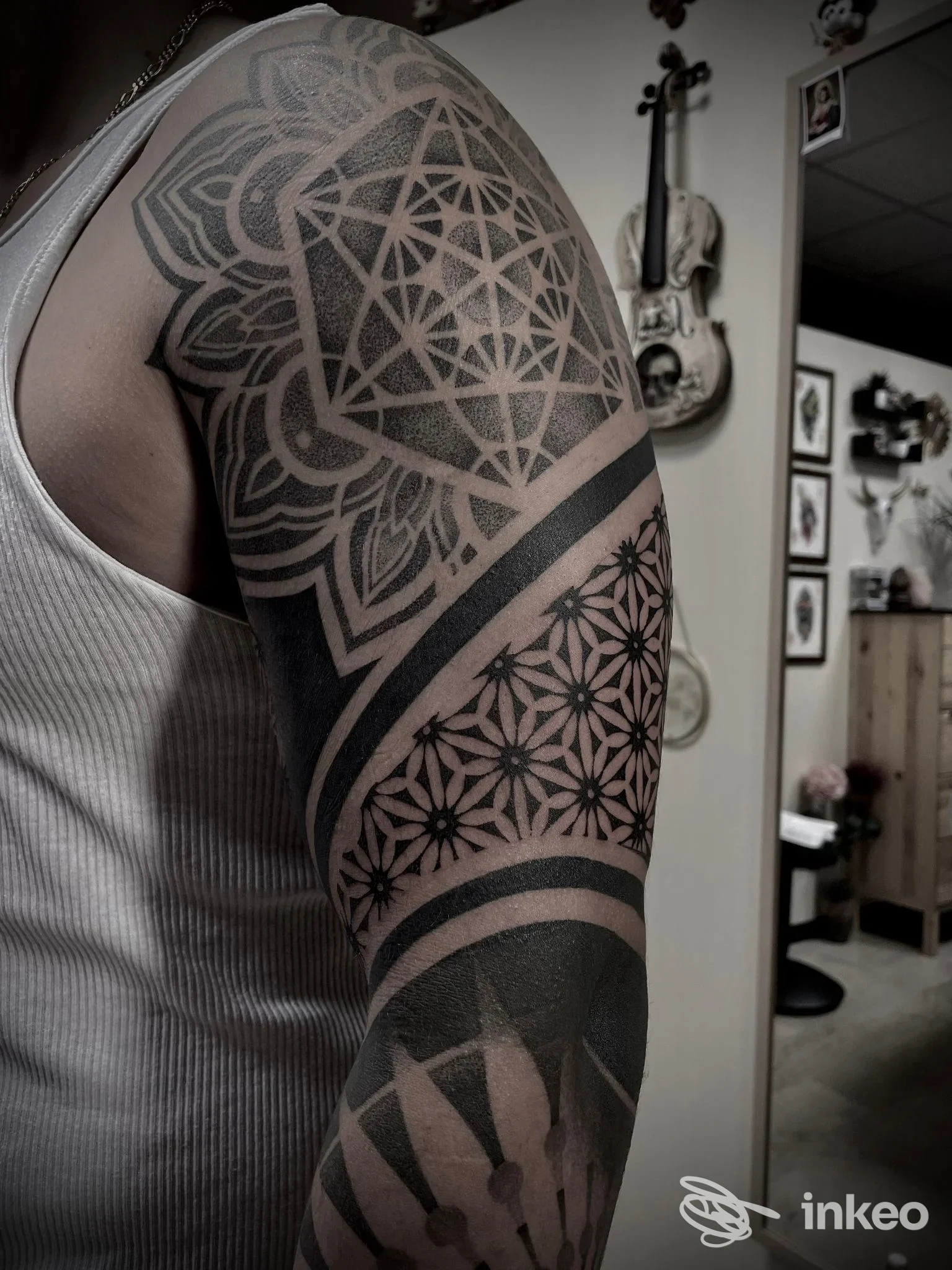 Tattoo geometrico a manica sul braccio realizzato da Badinka Tattoo a Maniago, dettagli ornamentali in nero e sfumature puntinate.