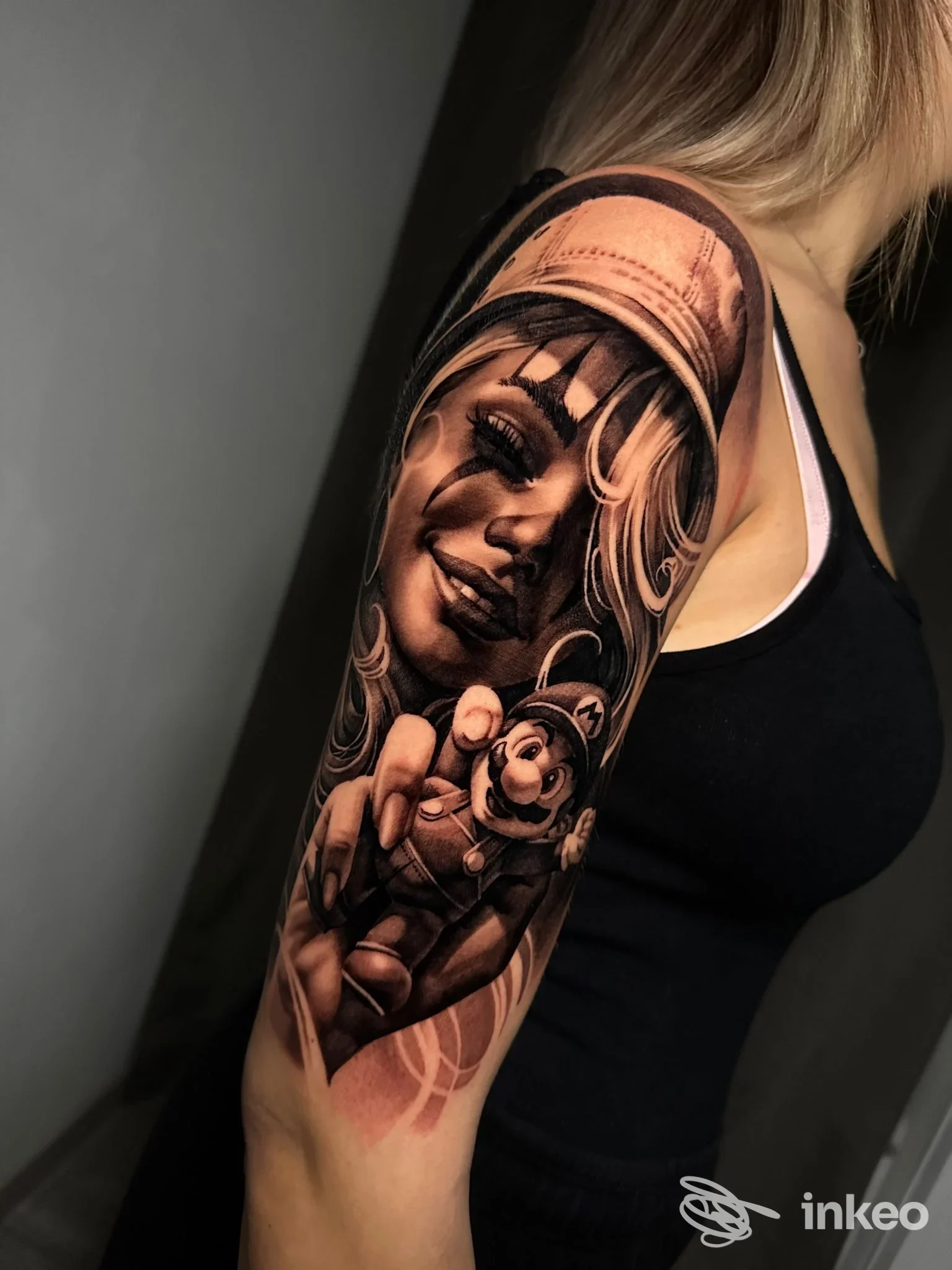 Tatuaggio realistico a mezza manica con volto femminile e bambola, eseguito da Sinked Art Tattoo Atelier a Pordenone.
