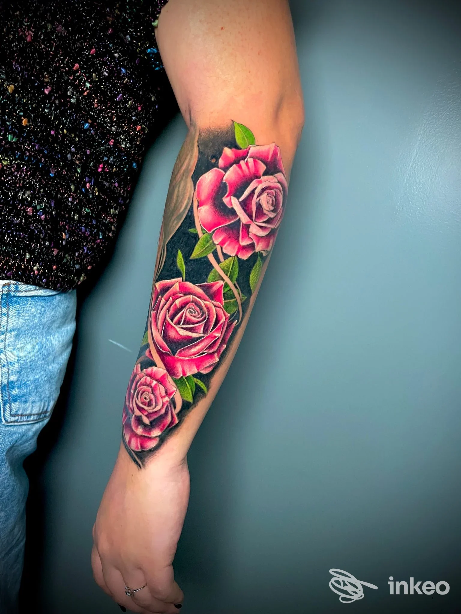 Avambraccio sinistro tatuato con tre rose rosa e foglie verdi, foto per Different Tattoo Studio a Pasian di Prato.