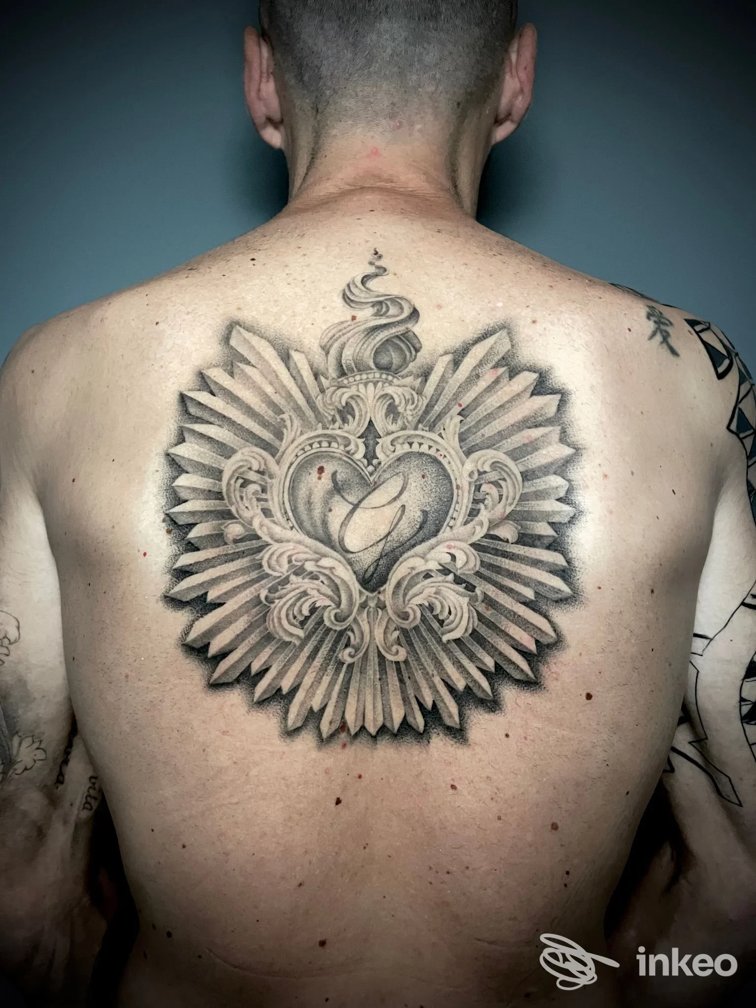 Grande tatuaggio ornamentale in bianco e nero sulla parte superiore della schiena. Immagine fornita da Different Tattoo Studio, Pasian di Prato.
