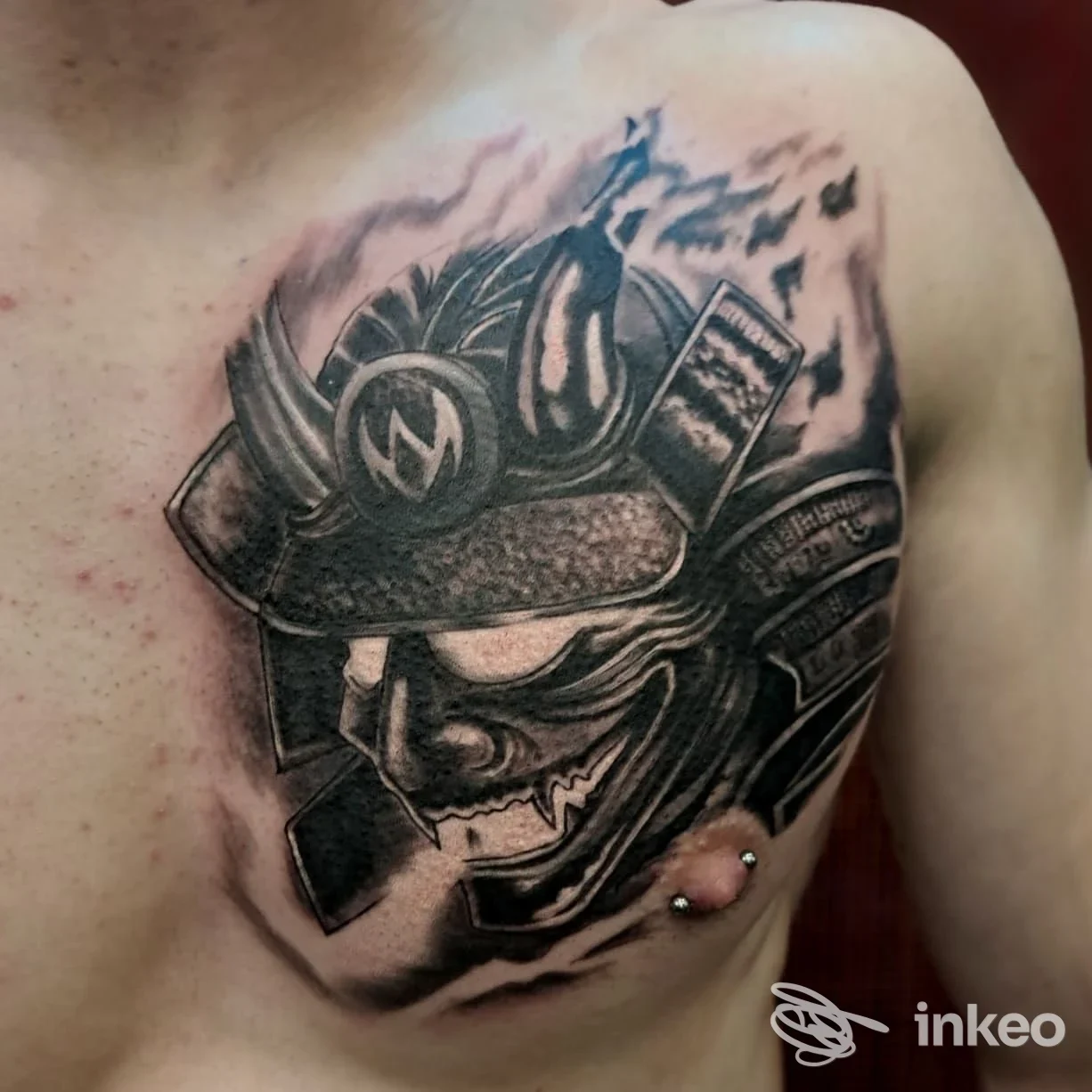 Tatuaggio samurai in bianco e nero sul petto con piercing, Second Skin, Trieste.