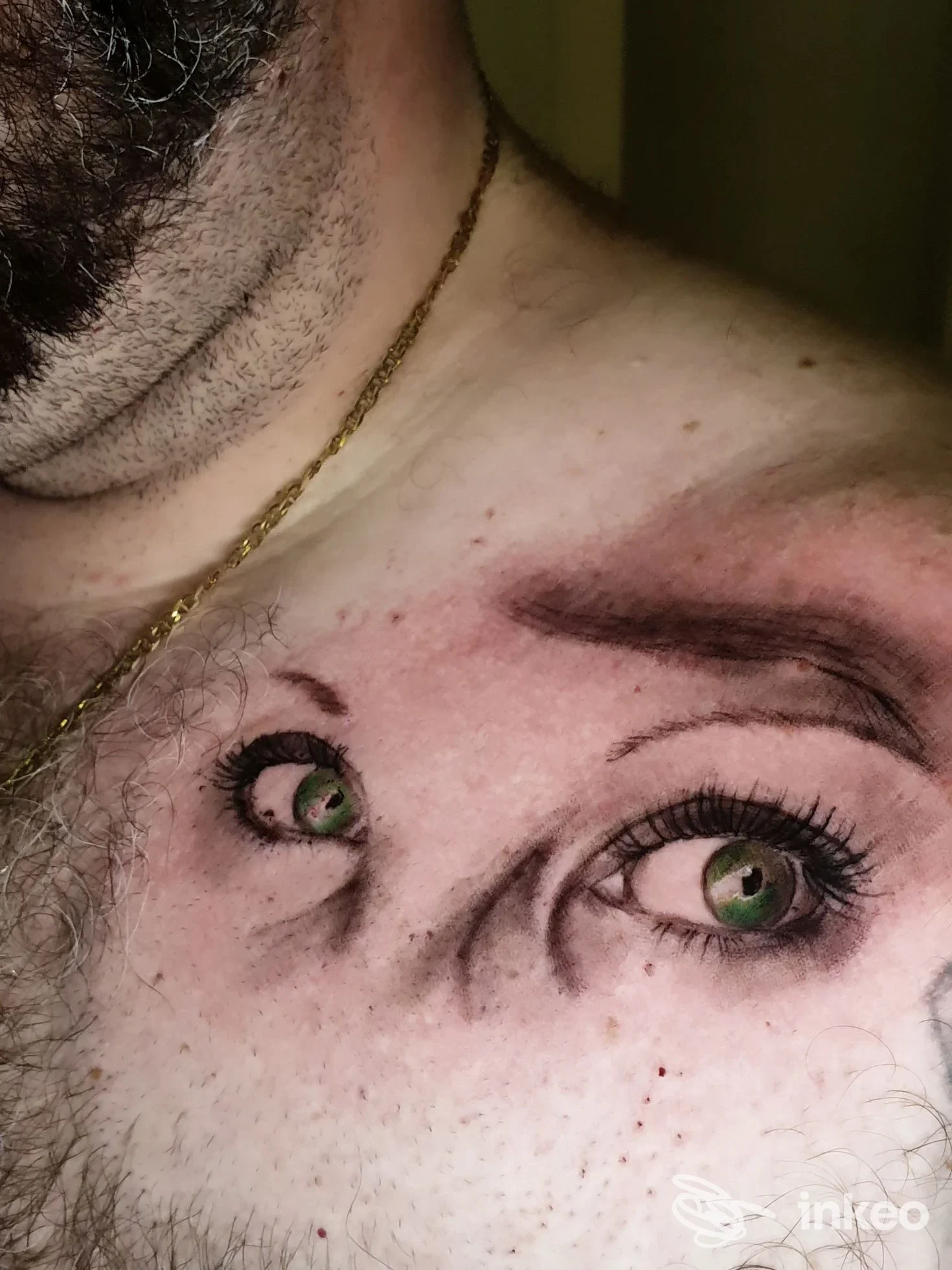 Tatuaggio realistico di occhi con iridi verdi sul petto, foto inviata da Ad Astra tattoo atelier a Gorizia.