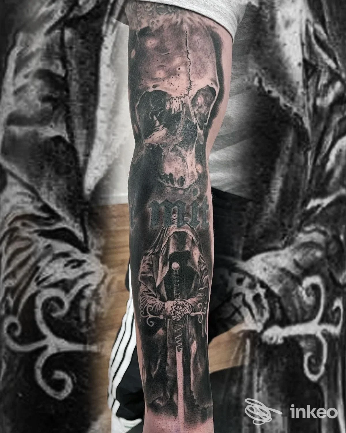 Manica tatuata bianco e nero con teschio e figura incappucciata, immagine fornita da Pitt Tattoo Studio, Udine.