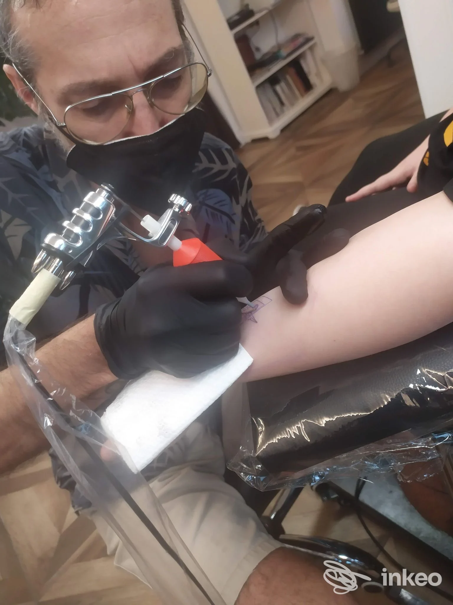 Tatuatore al lavoro sull'avambraccio di un cliente presso La Machine tattoo, Trieste.