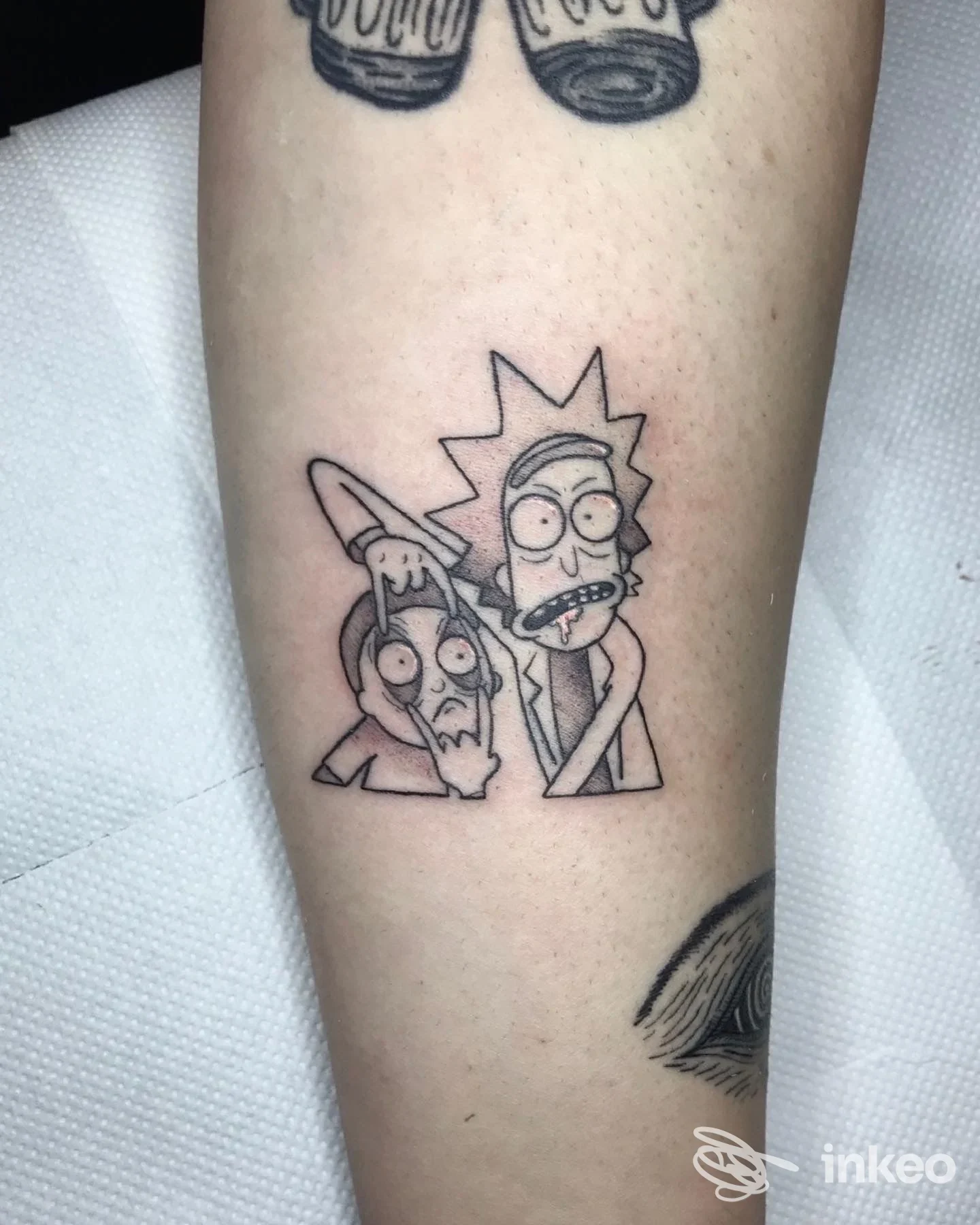 Tatuaggio in bianco e nero di Rick e Morty sull'avambraccio, realizzato presso Another One - Tattoo & Art Studio, Cormons.