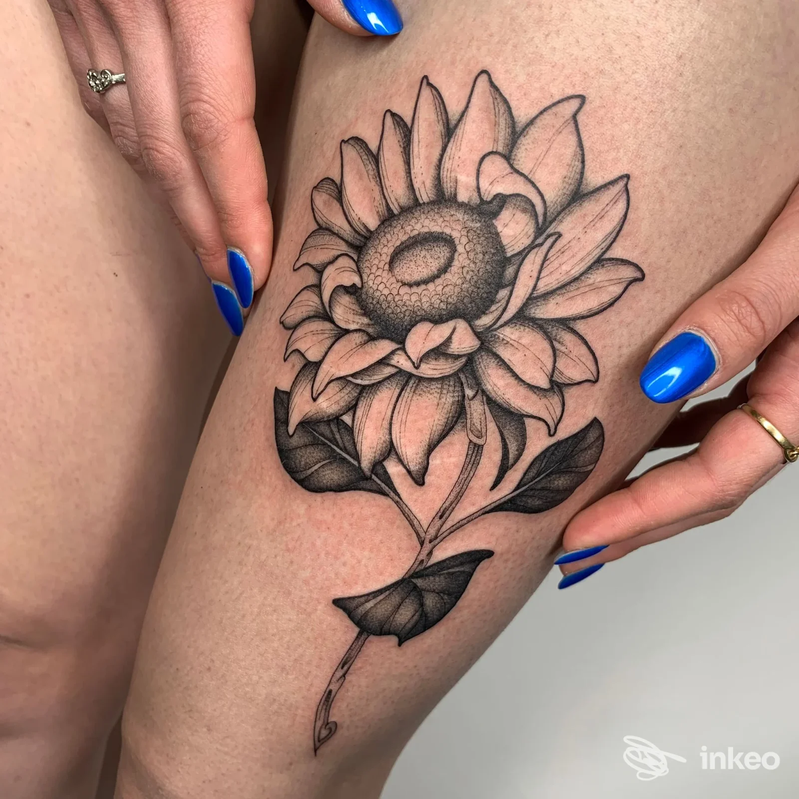 Tatuaggio a girasole in bianco e nero sulla coscia, foto di La Burra Tattoo Studio a Cividale del Friuli.