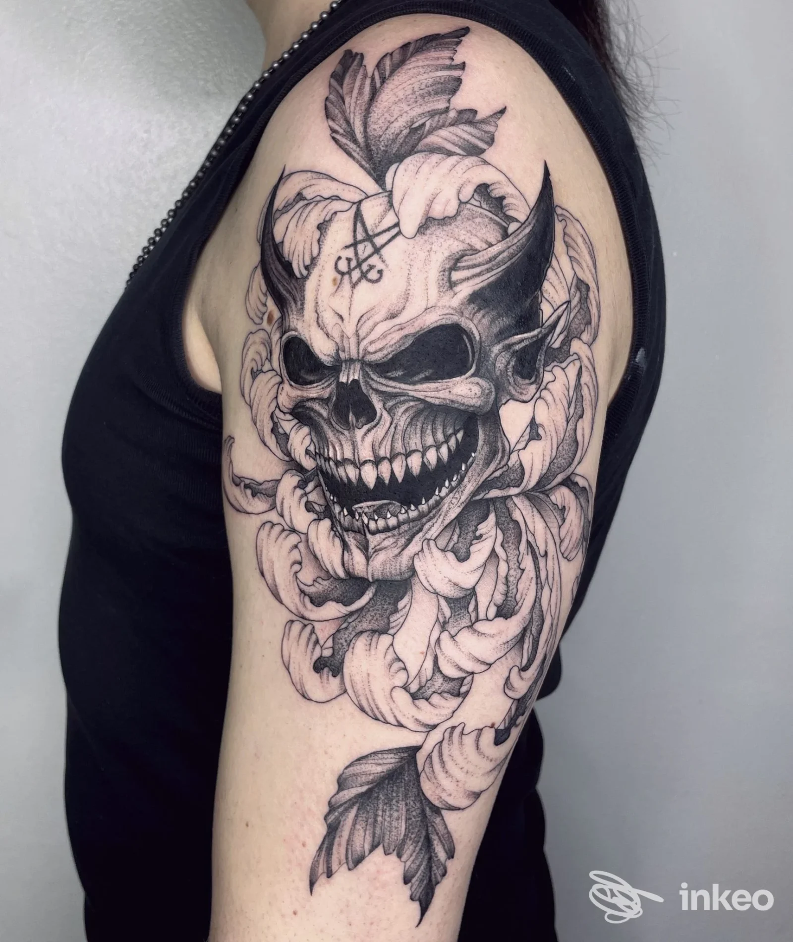 Dettaglio di un tatuaggio black & grey a forma di teschio con fiori sul braccio/avambraccio superiore, NERO tattoo atelier, Duino Aurisina.