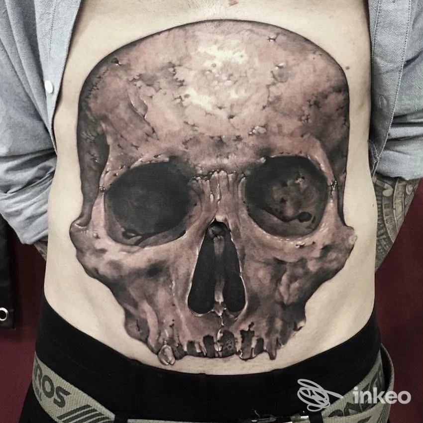 Grande tatuaggio realistico di cranio sull'addome, foto fornita da Attenti Al Lupo Tattoo, Chions.