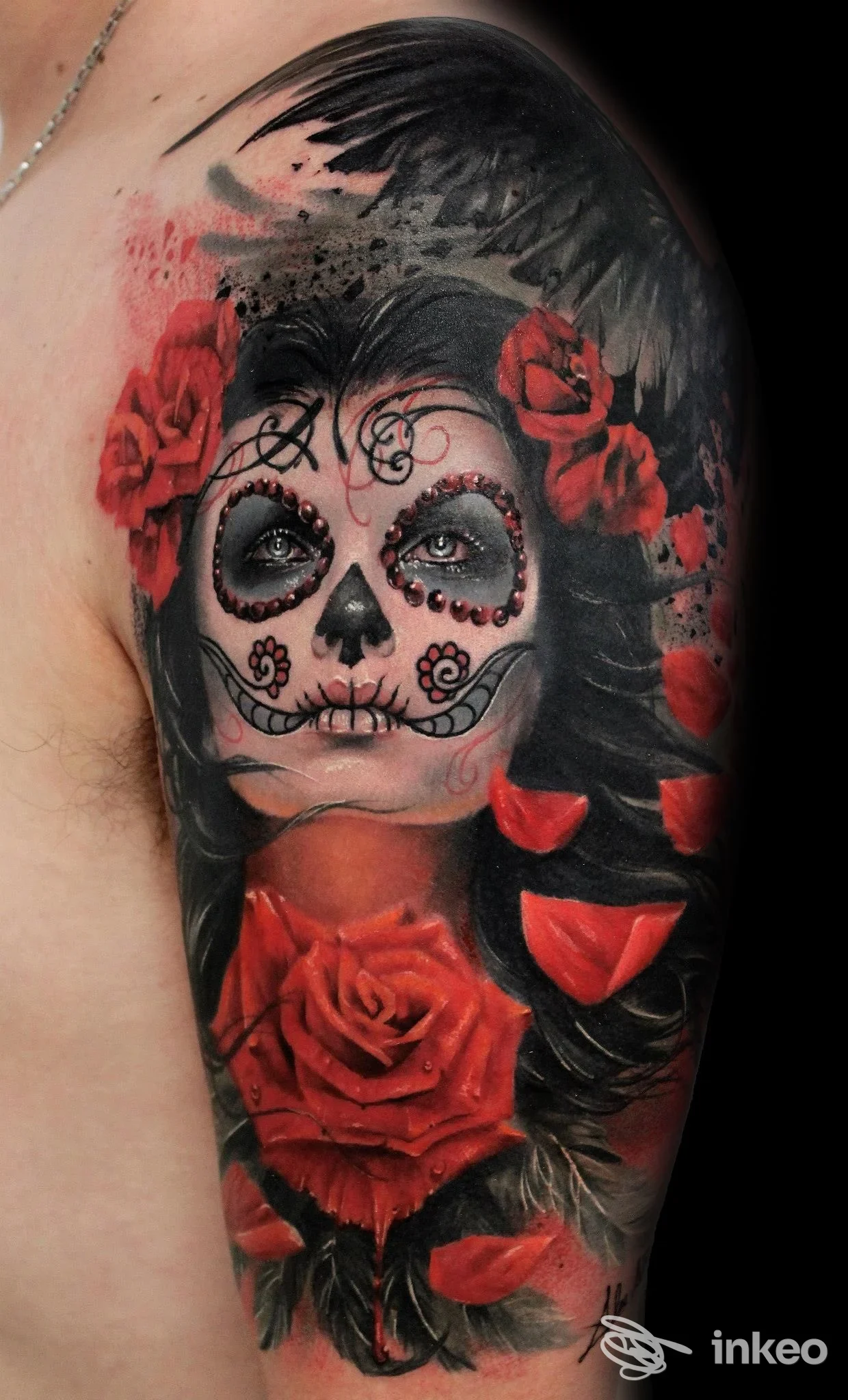 Tatuaggio sulla spalla e parte superiore del braccio raffigurante un volto in stile sugar skull con rose rosse. Ink Empire Tattoo & Piercing, Grado.
