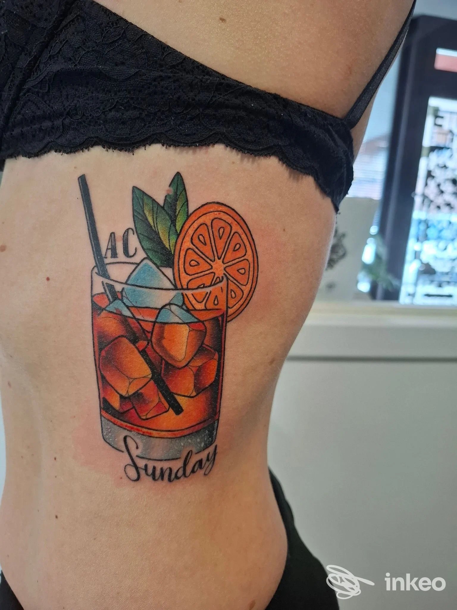 Tatuaggio colorato a tema cocktail sul fianco, foto fornita da Peto Tattoo, Sacile.